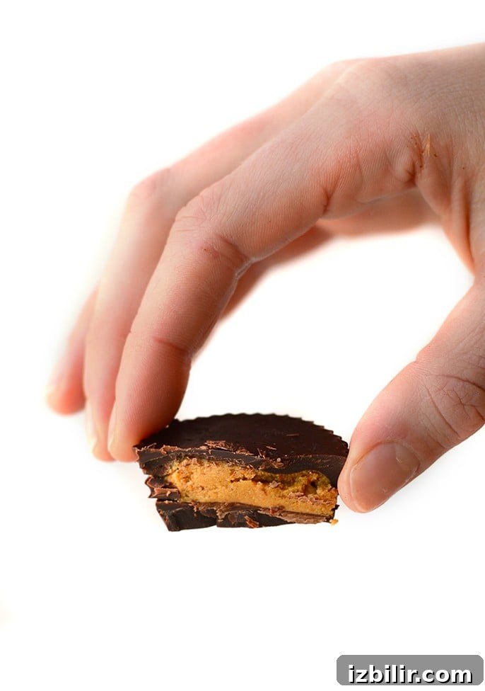Protein peanut butter cup hand holding peanut butter cup.