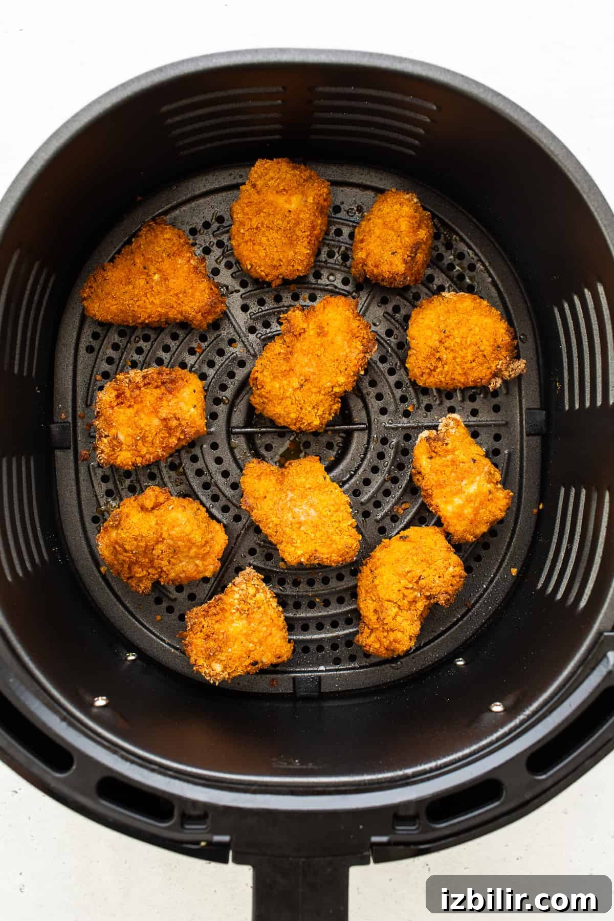 Air frying chicken Air frying chicken pieces in air fryer basket.