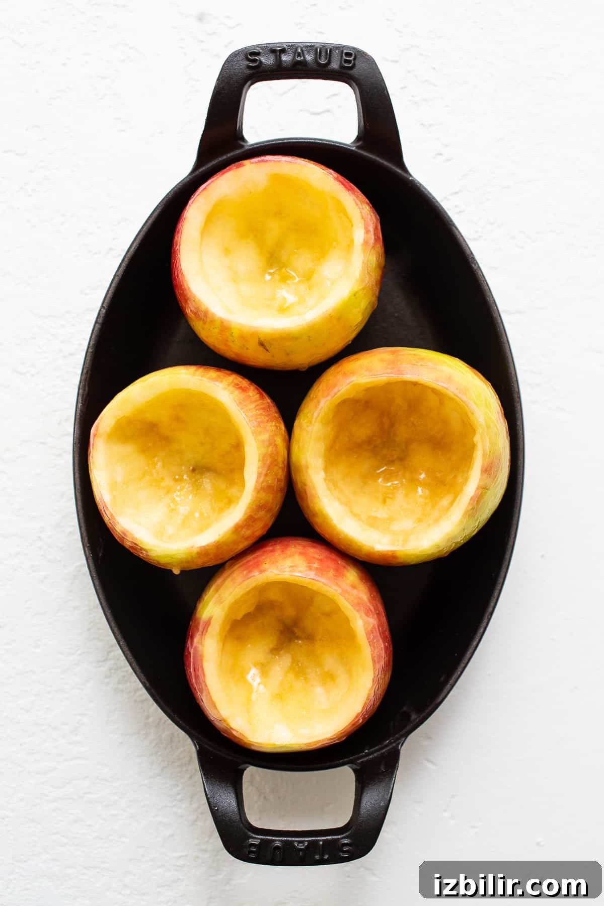 Cored apples ready to be filled. Cored apples in a baking dish.