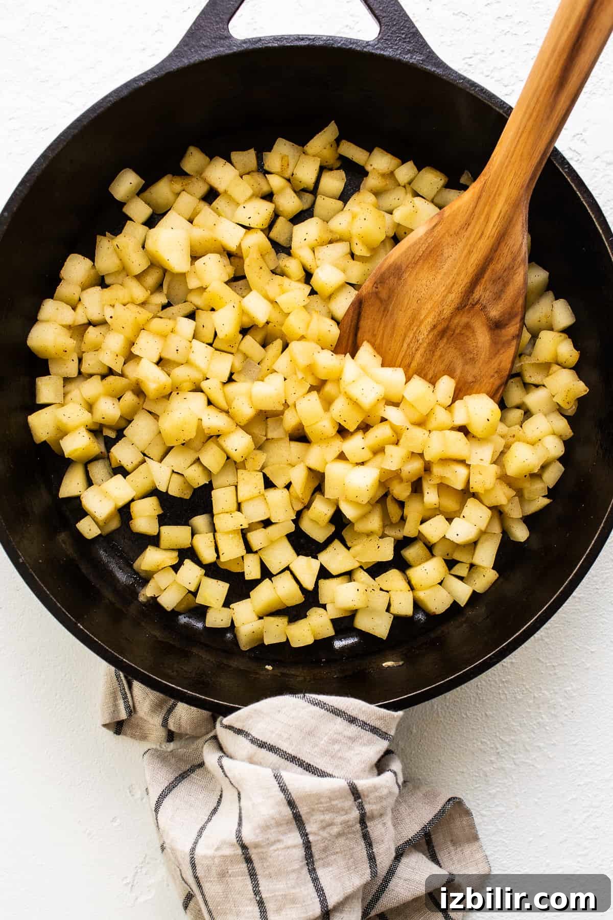 Honey crisp apples sauteing in a cast iron skillet.