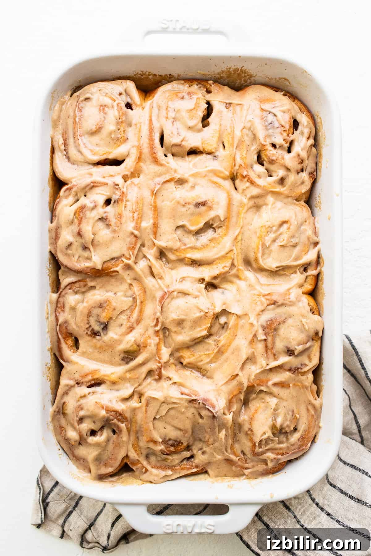 Apple cinnamon rolls covered in brown butter cream cheese frosting.
