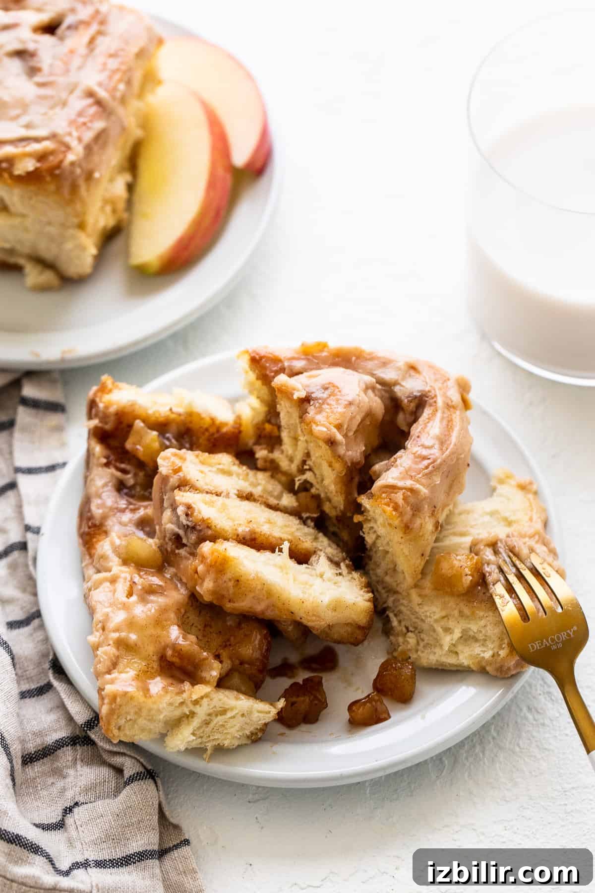 Apple cinnamon roll on a plate with a fork.