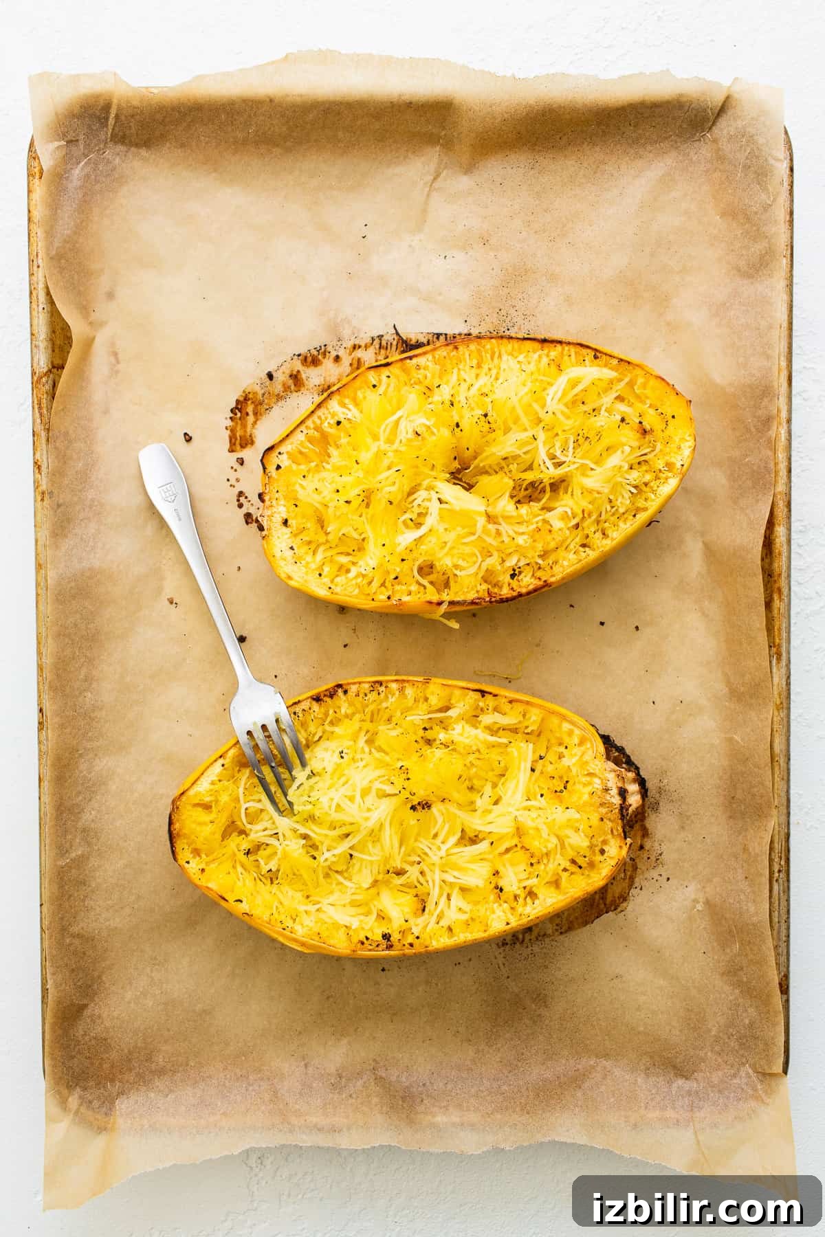 Roasted spaghetti squash halves Spaghetti squash on a baking sheet.