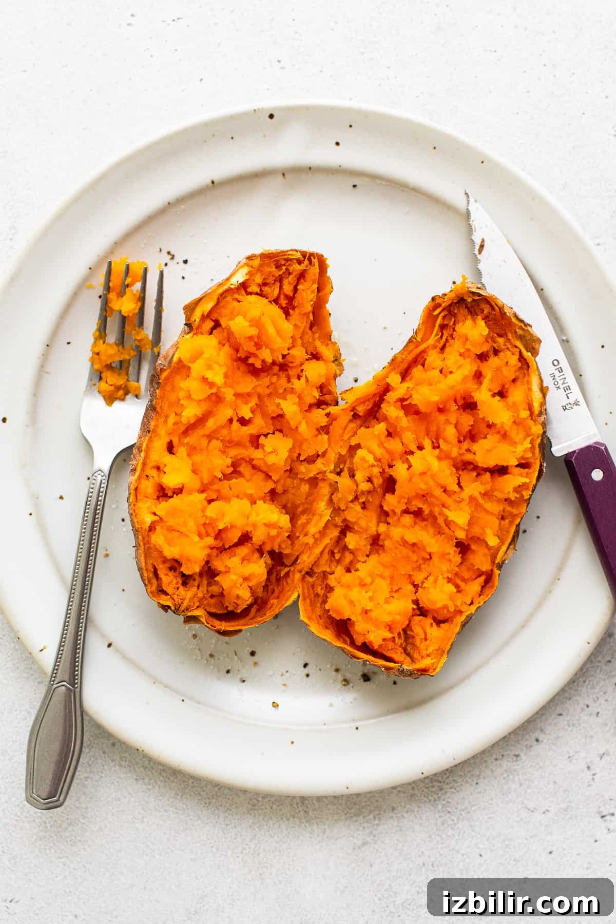 Microwave Sweet Potato to Tender Perfection 6 A sweet potato cut in half on a plate.