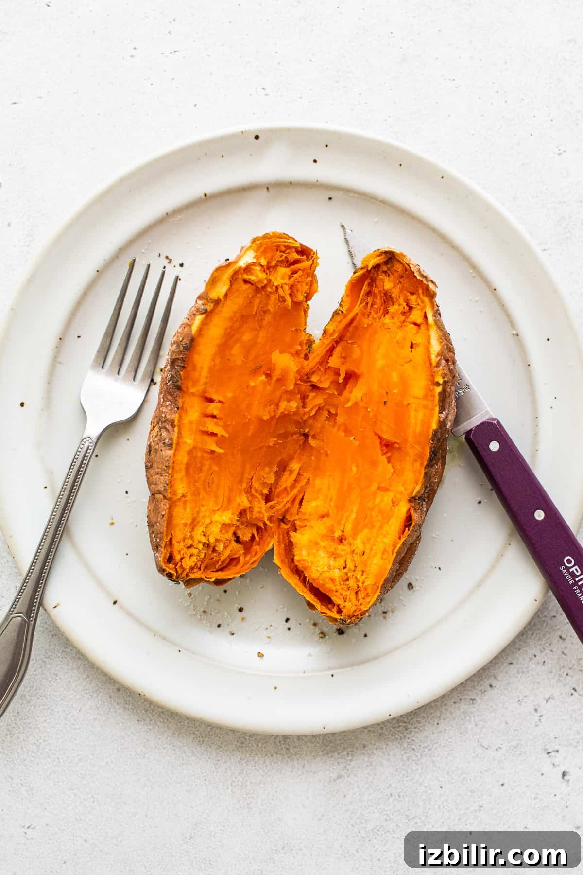 Microwave Sweet Potato to Tender Perfection 5 A sweet potato cut in half on a plate.