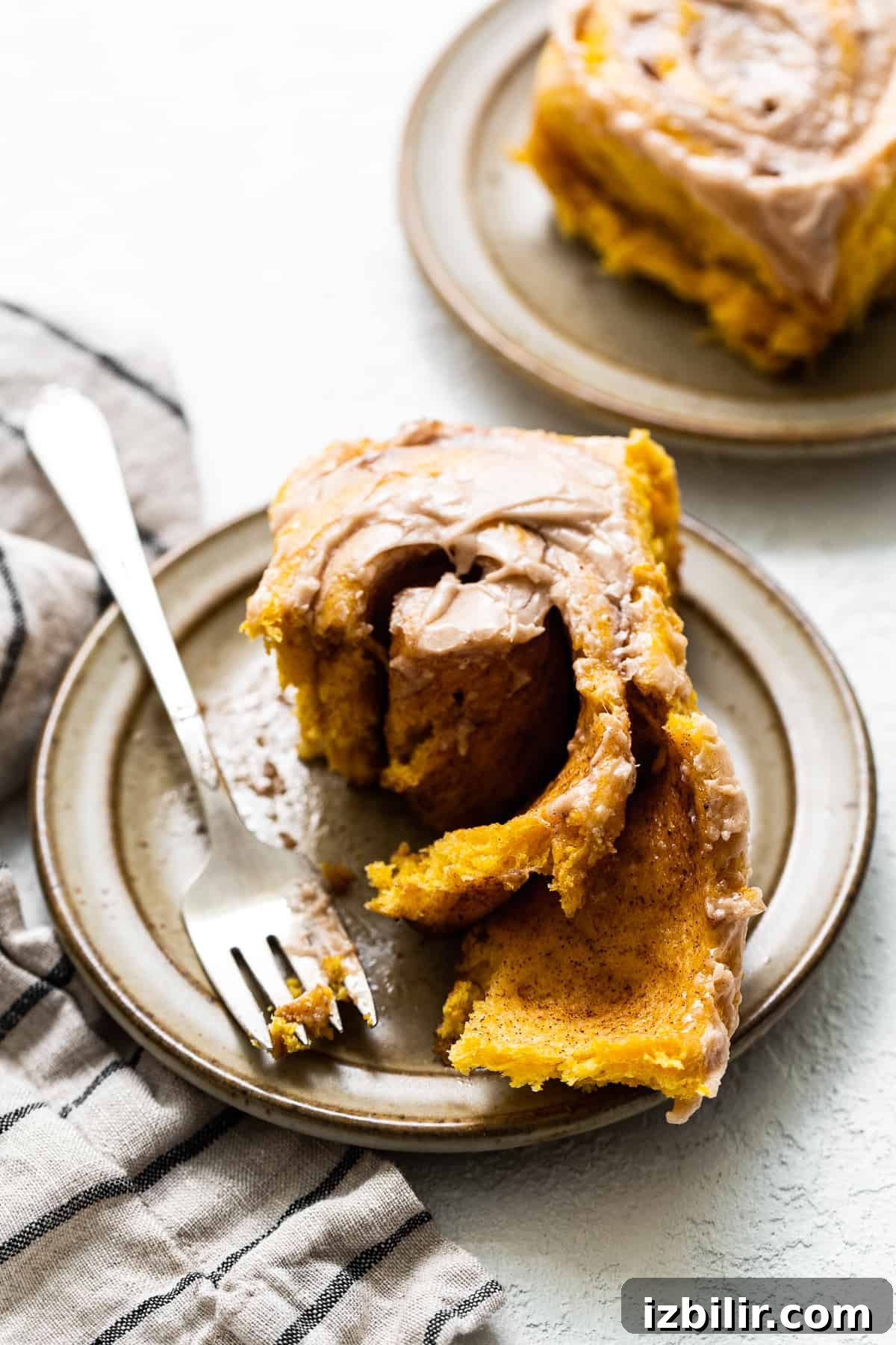 Fluffy Pumpkin Cinnamon Rolls with Cream Cheese Glaze 5 Pumpkin cinnamon roll on a plate.