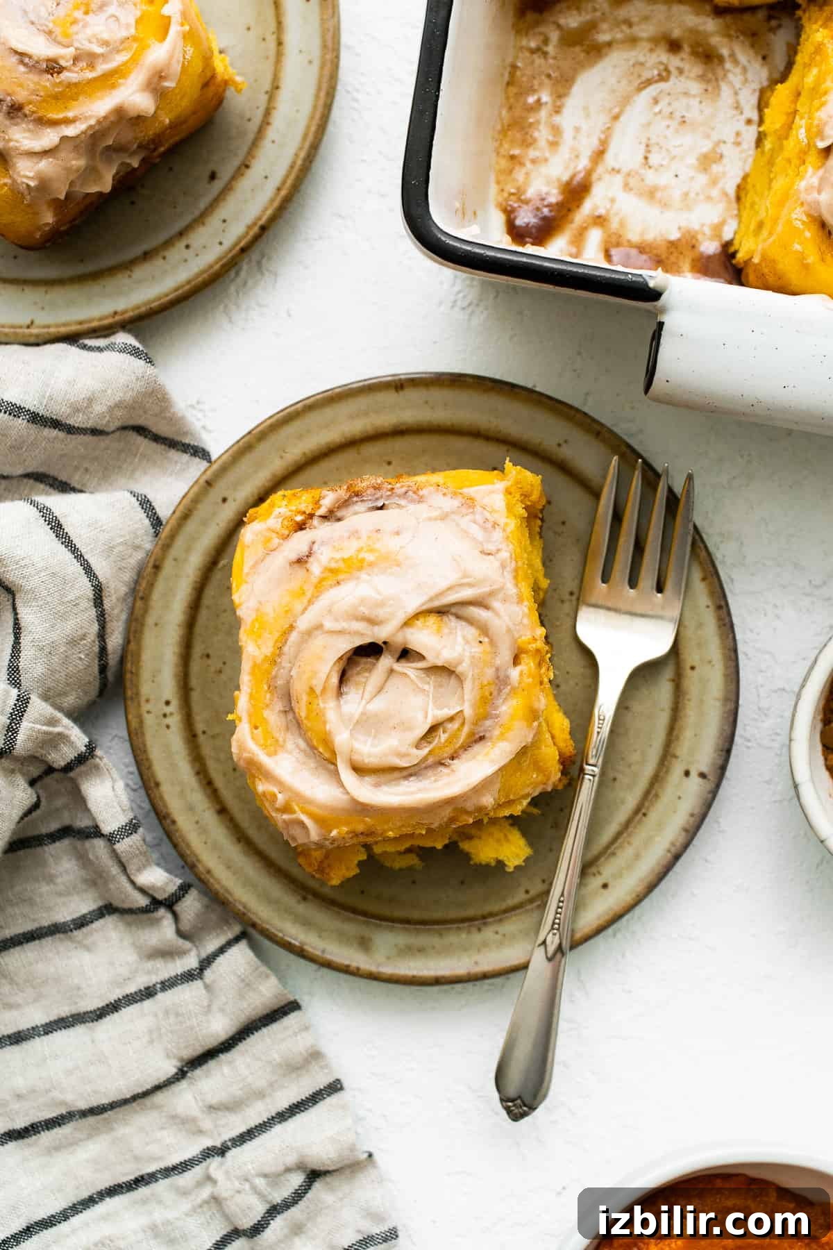 Fluffy Pumpkin Cinnamon Rolls with Cream Cheese Glaze 6 Pumpkin cinnamon roll on a plate with a fork.