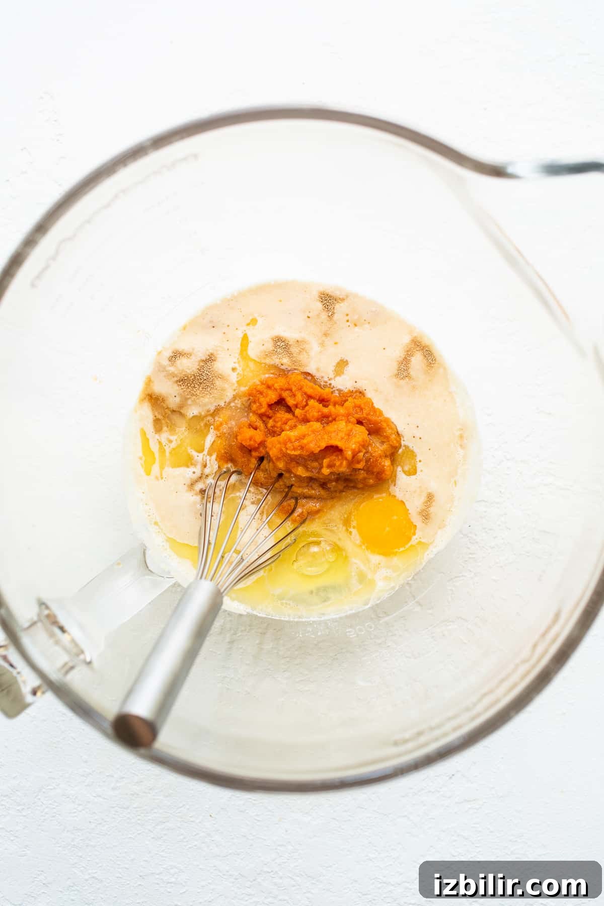 Pumpkin cinnamon roll ingredients Wet ingredients for pumpkin cinnamon rolls in a bowl.