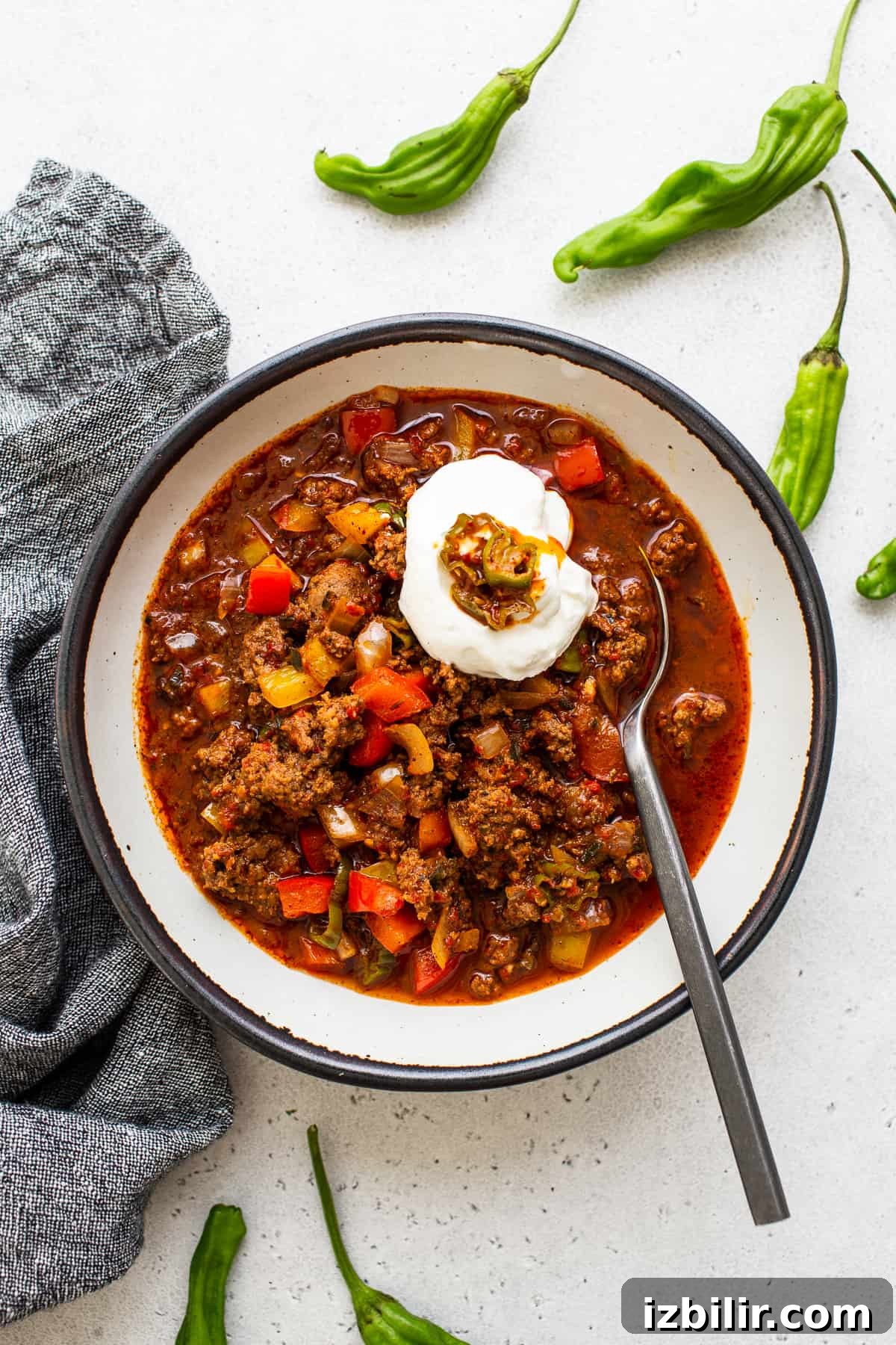 Authentic Texas Chili Recipe with Smoky, Spicy Flavor 6 Texas chili in a bowl topped with sour cream and hatch chilis