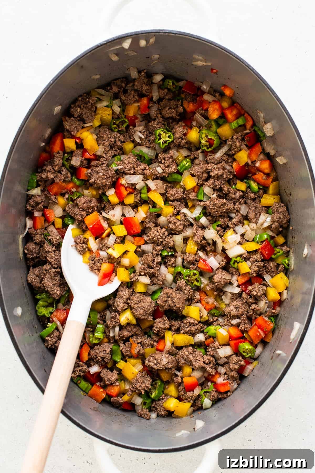 Authentic Texas Chili Recipe with Smoky, Spicy Flavor 4 Ground beef, peppers, and onion cooking in a pot