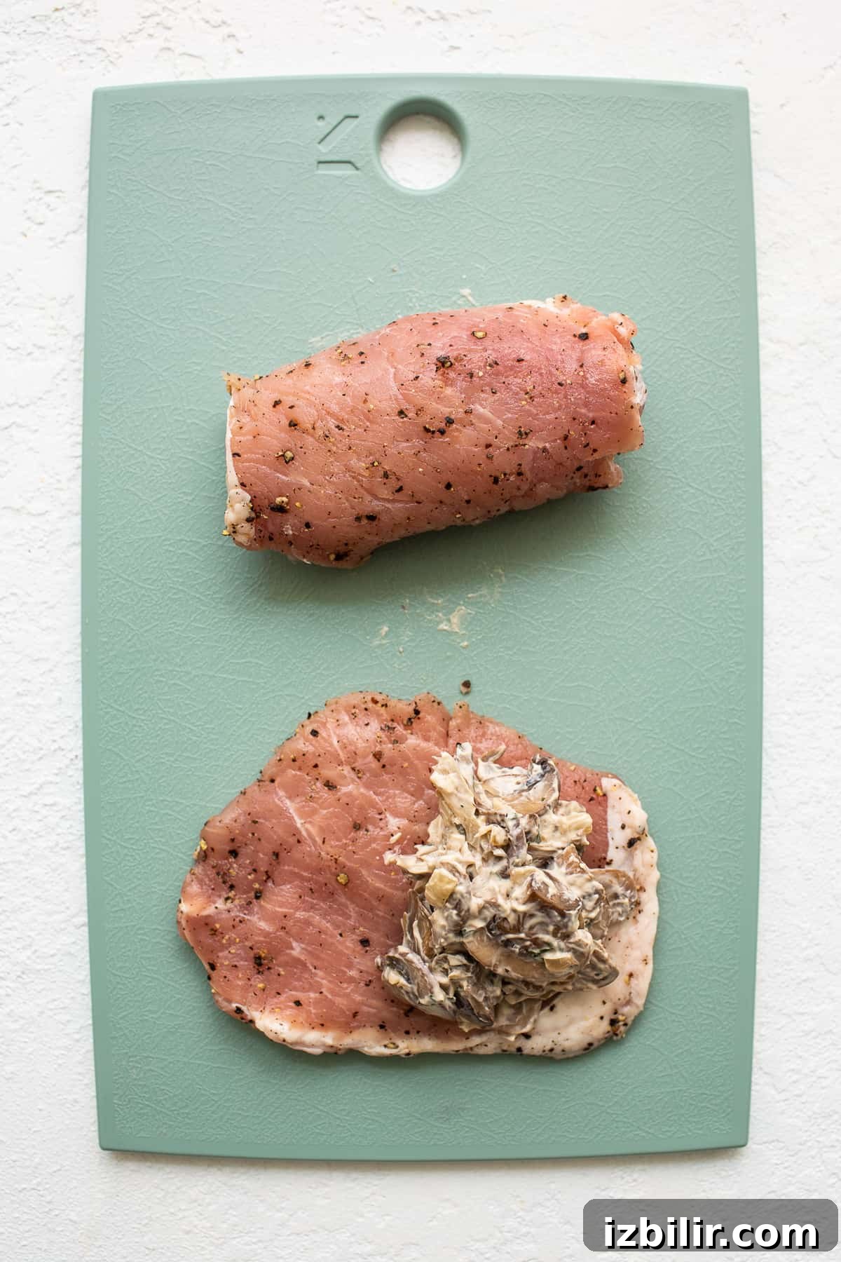 Stuffing pork chops on cutting board