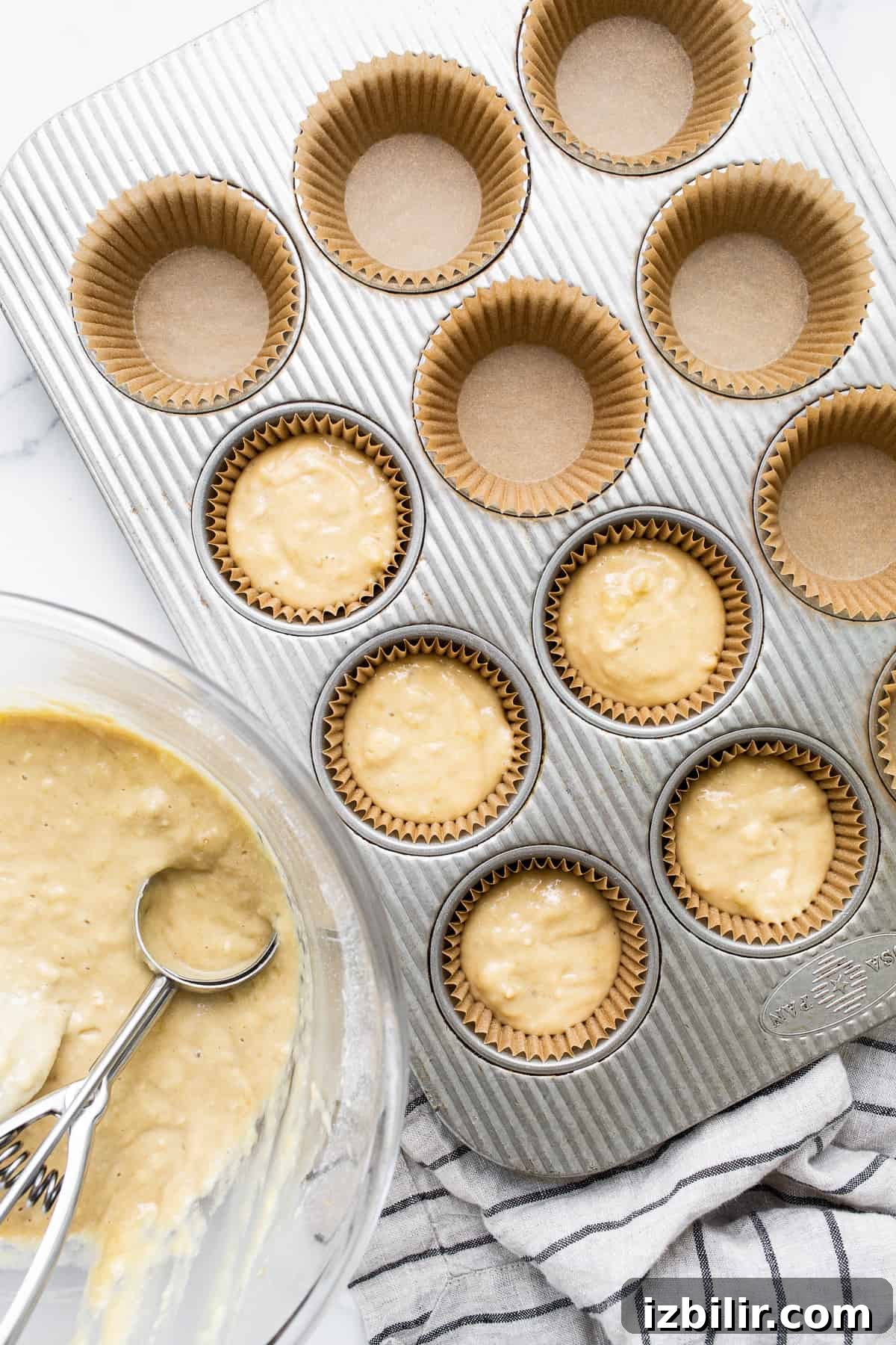 Welcome to January 2023’s edition of Fit Foodie Cooking Club — our amazing banana bread muffins! You’ll absolutely love these fluffy muffins. Banana bread muffin batter in muffin tins.