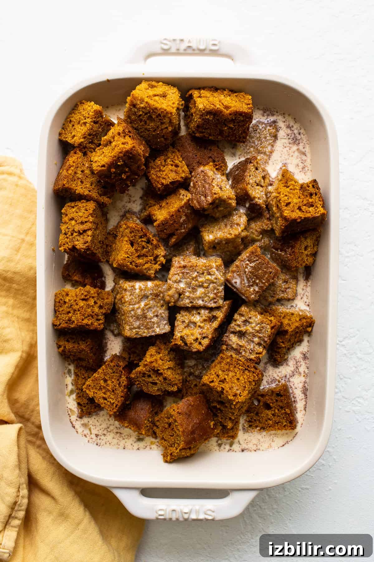 pumpkin bread pudding cubes soaking in egg.