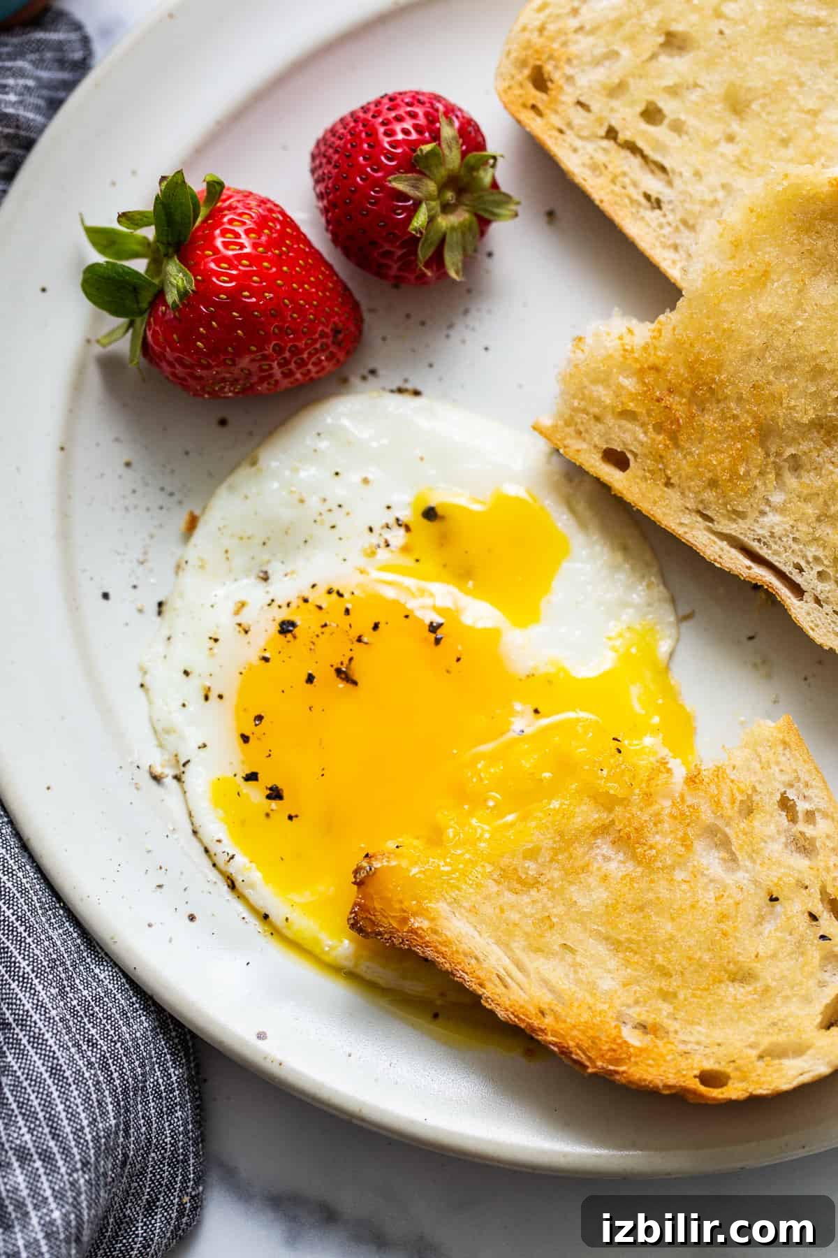 A runny yolk and a piece of buttered toast.