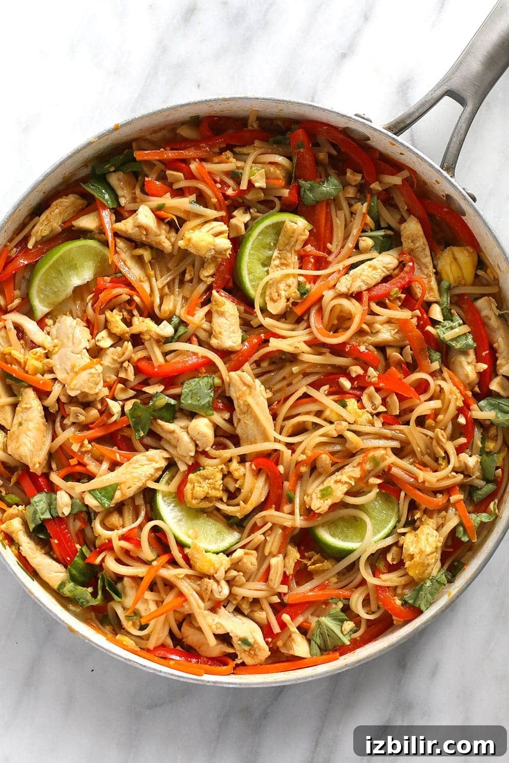 Chicken pad Thai mixed together and ready to eat in a pan.