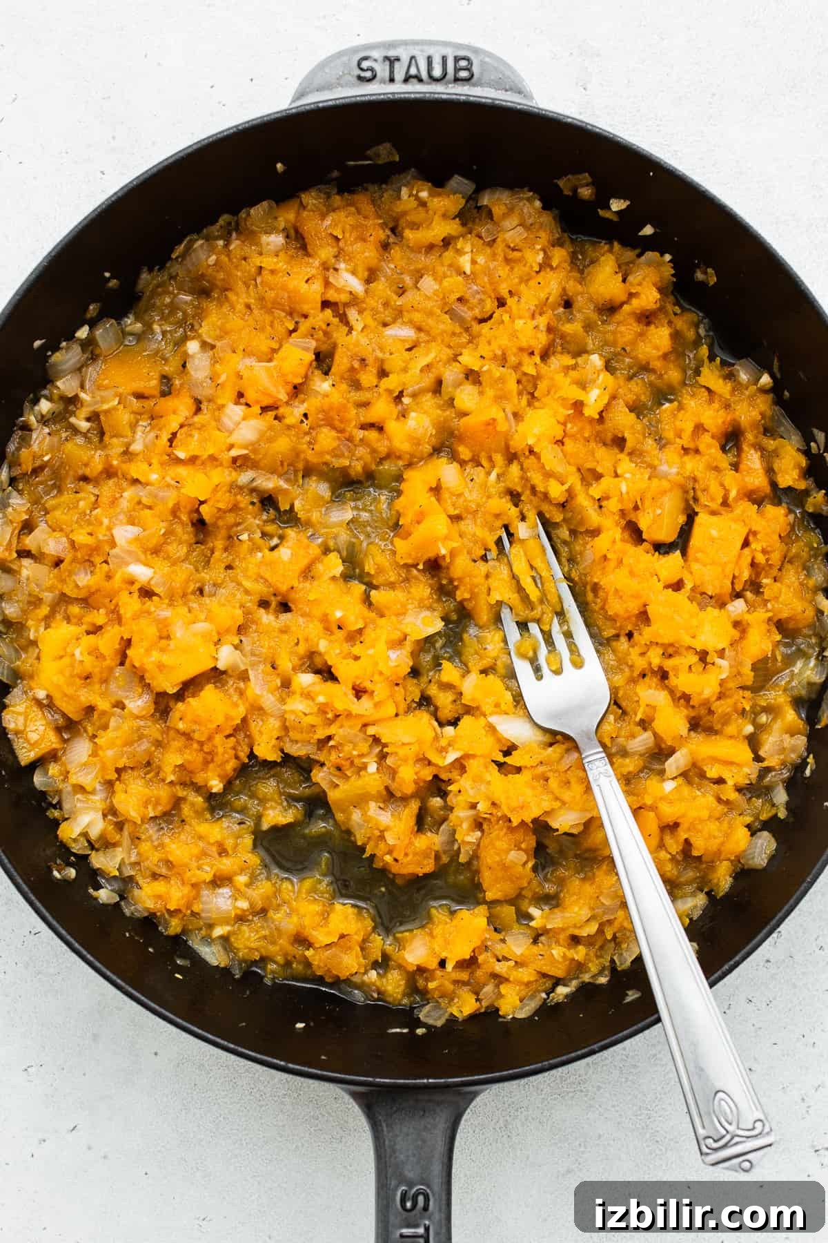 Smashing butternut squash with the back of a fork. 
