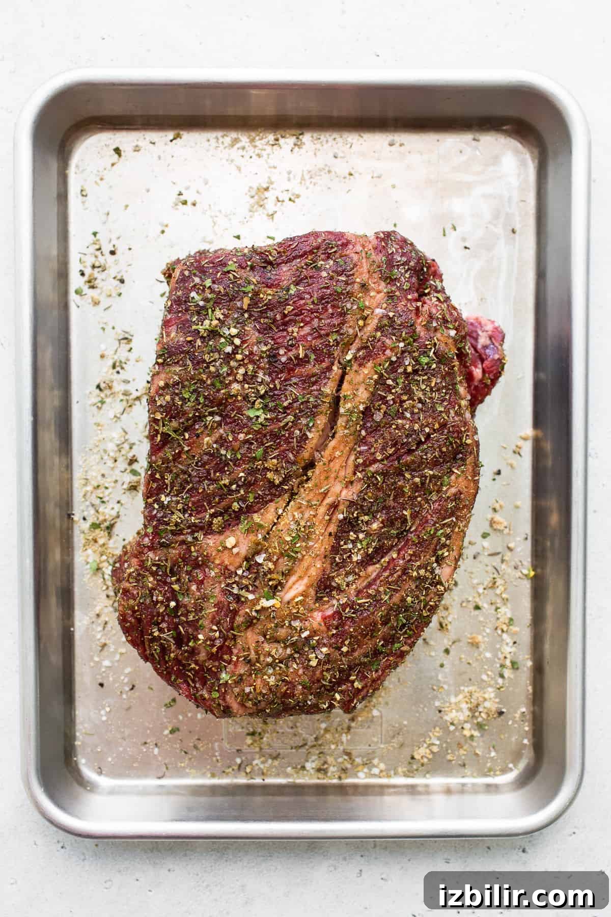 Raw chuck roast ready to be seasoned and seared. Raw chuck roast on a baking sheet.