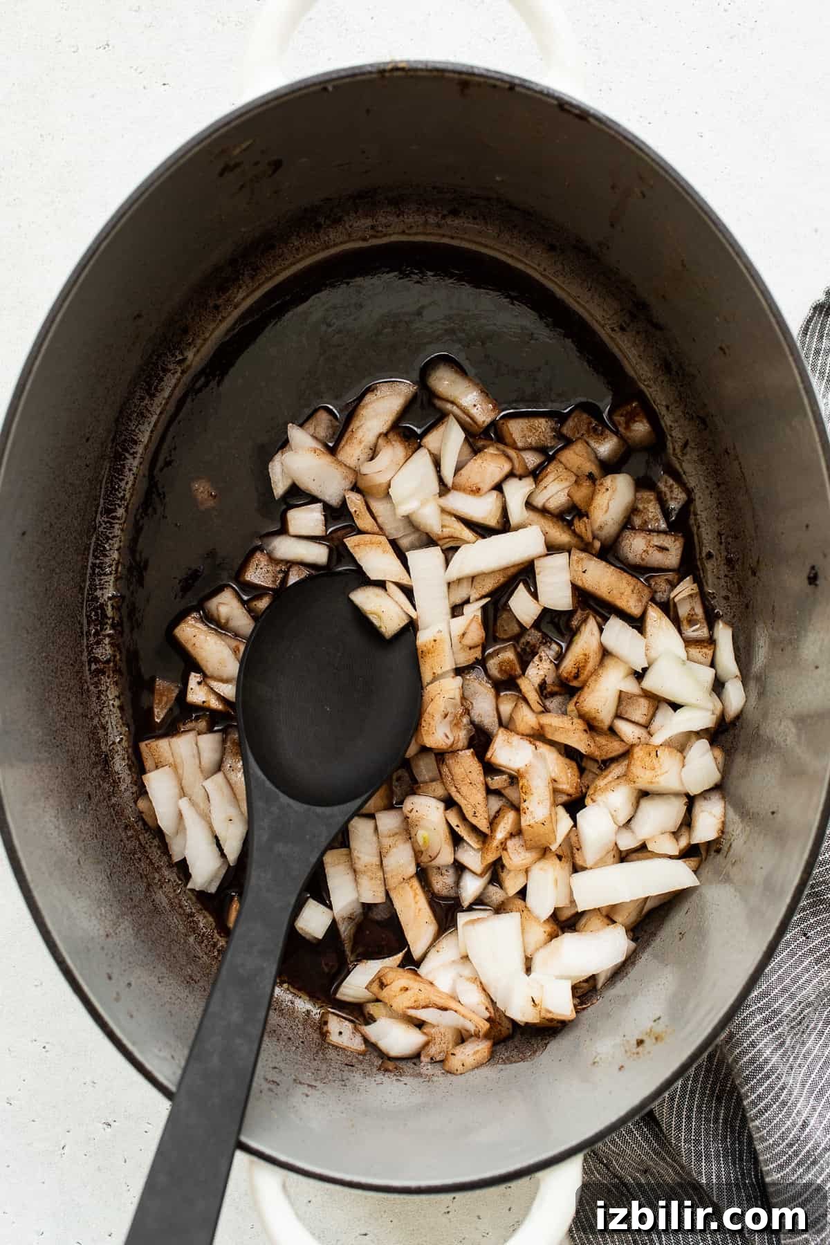 Onions sautéing in a Dutch oven. Diced onions in a dutch oven.