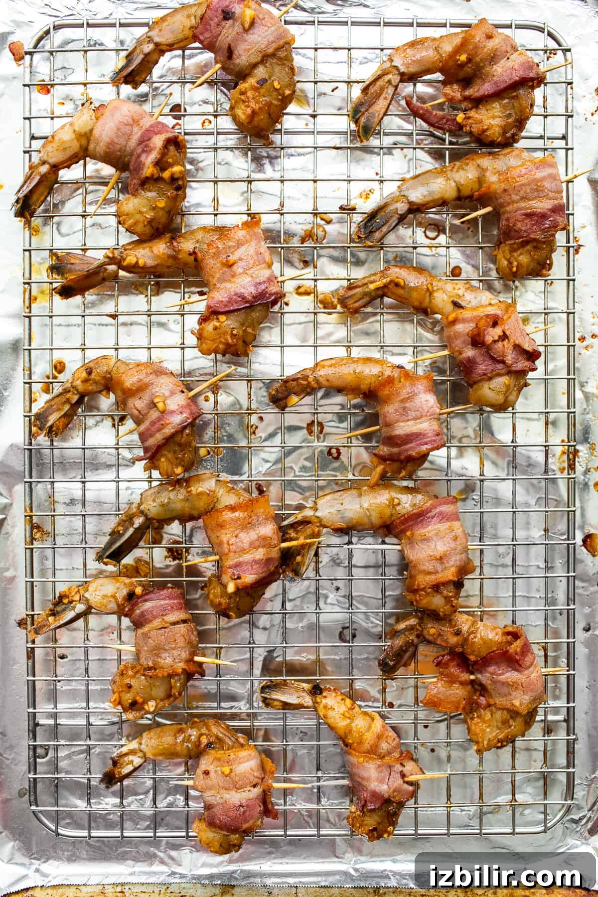 Bacon wrapped shrimp on a baking sheet.