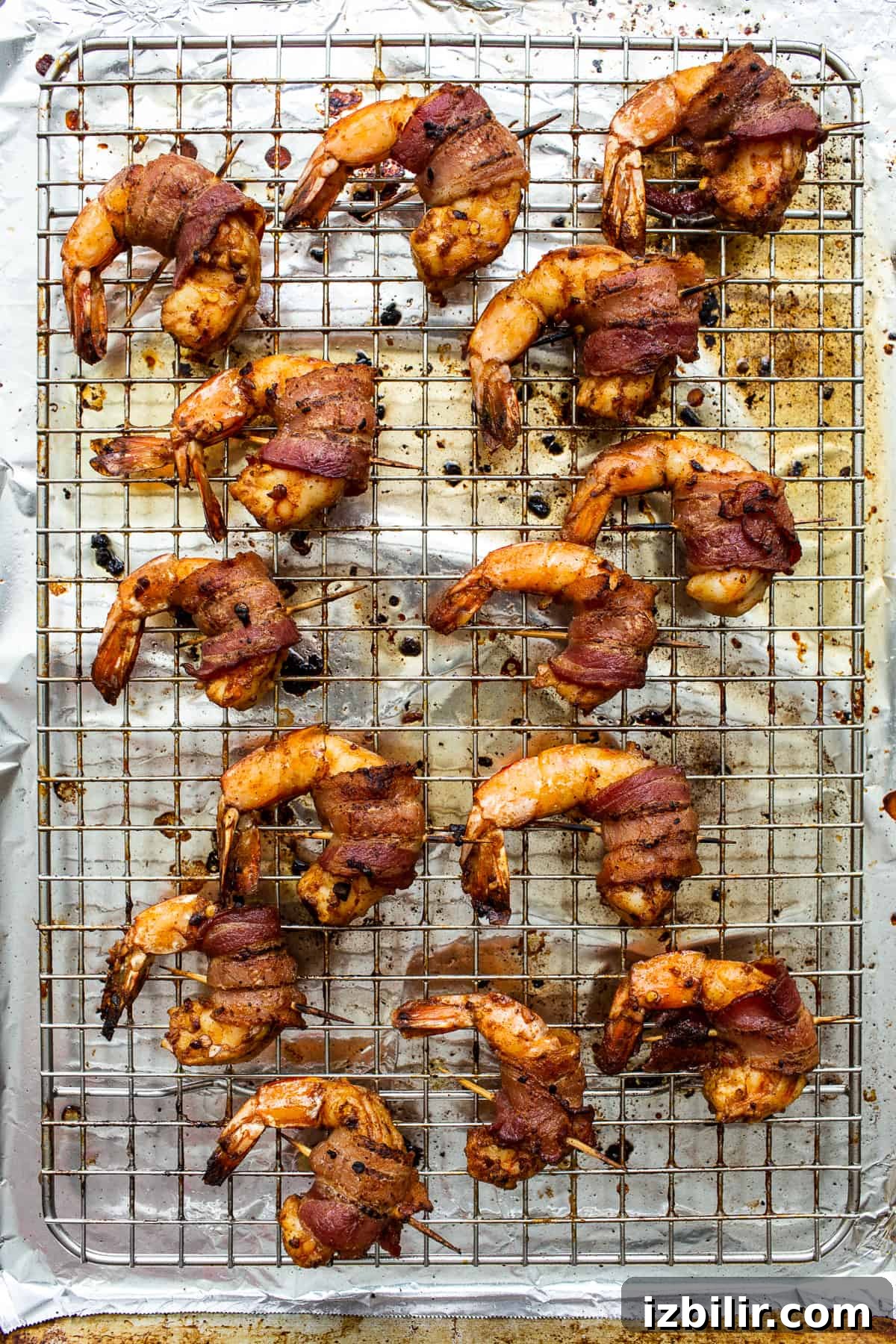Bacon wrapped shrimp on a baking sheet.