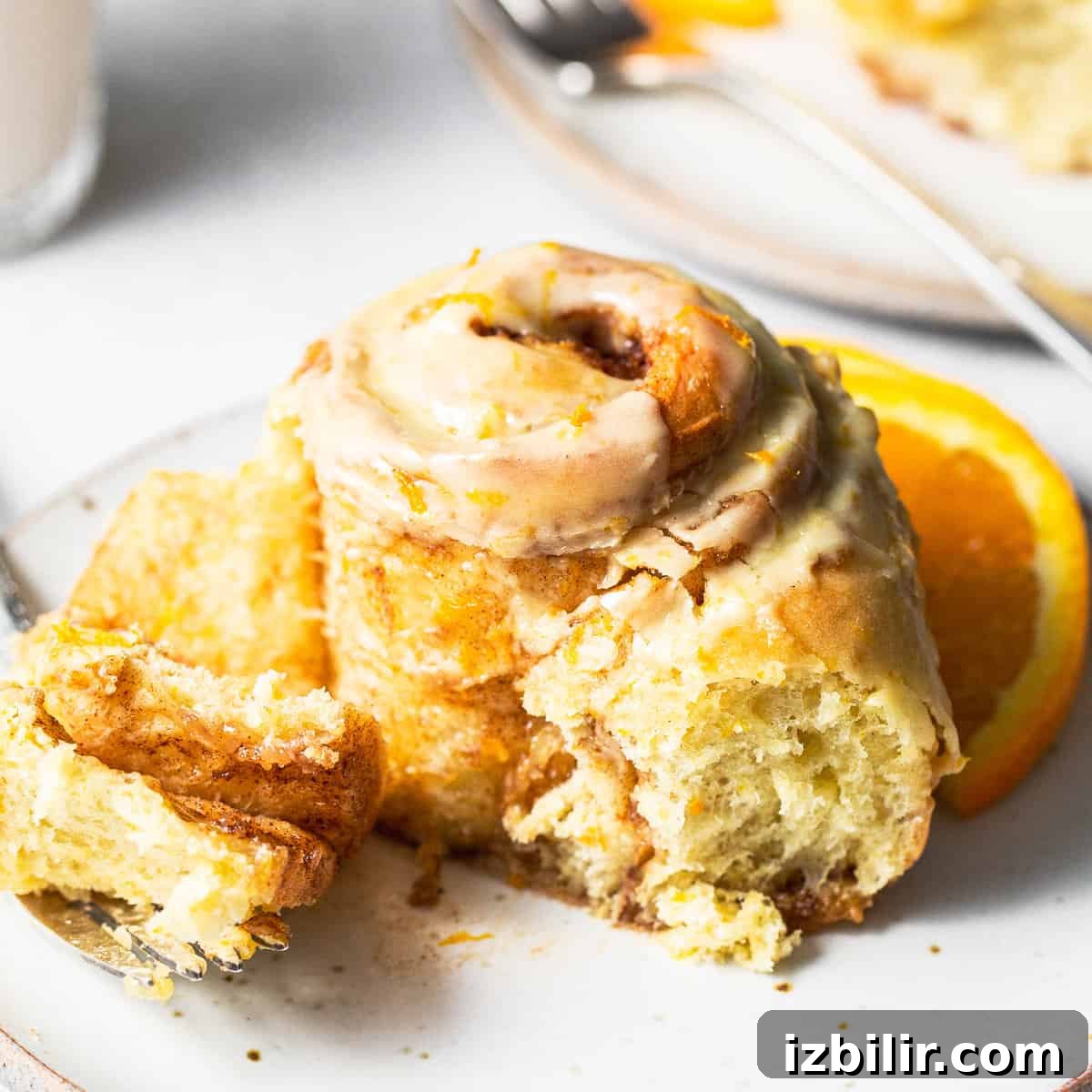 Orange-Glazed Sweet Rolls Recipe 6 An orange roll with a bite taken out of it.