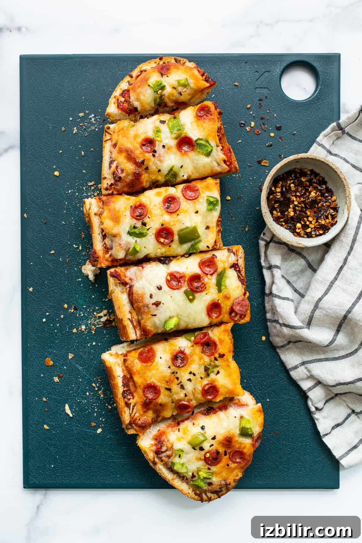 French bread pizza on a cutting board.