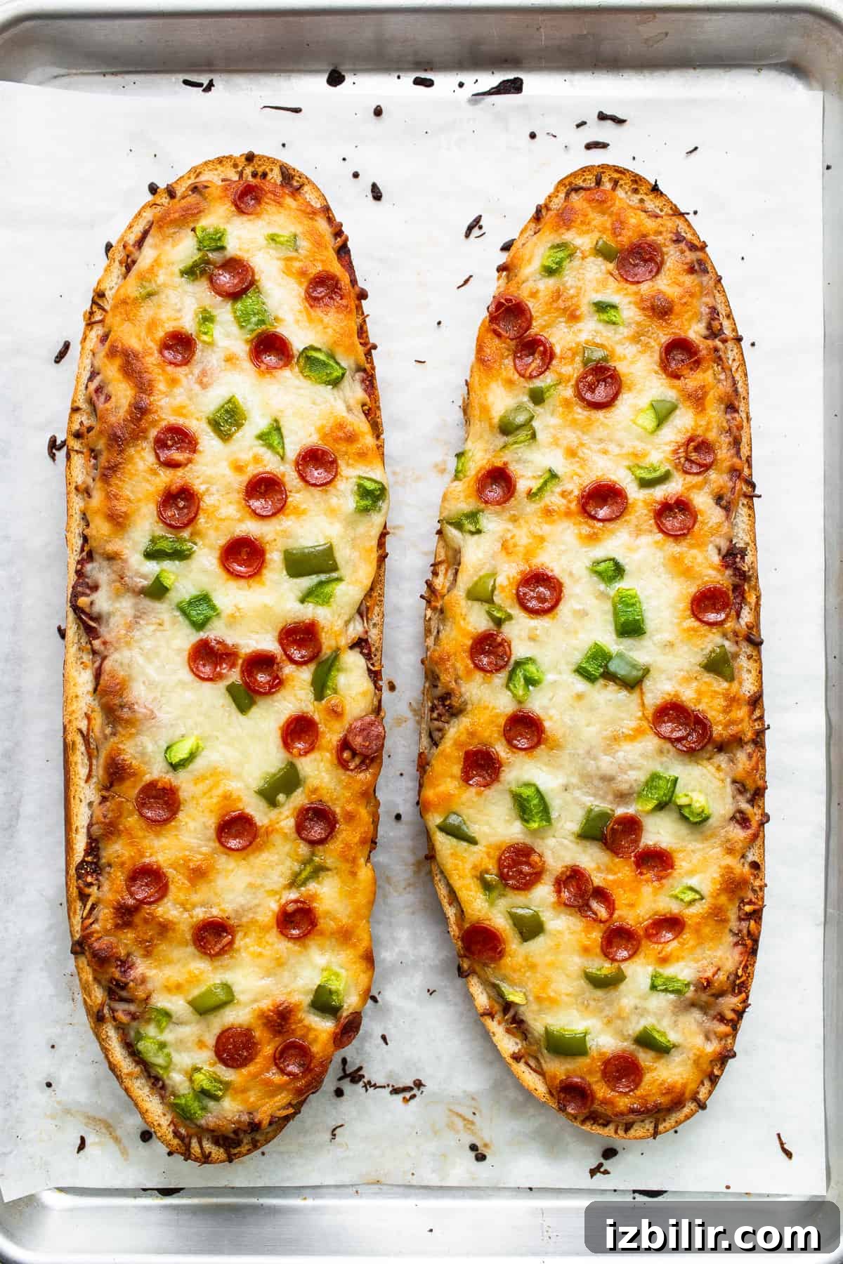 Cooked french bread pizza on a baking sheet.