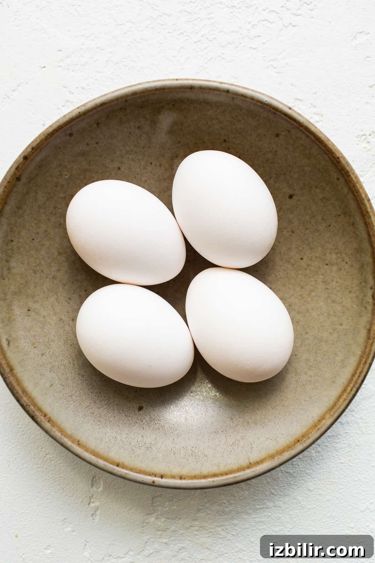 This over easy eggs recipe uses a simple technique that creates the perfect runny yolk and fluffy egg whites every time. Eggs in a bowl.