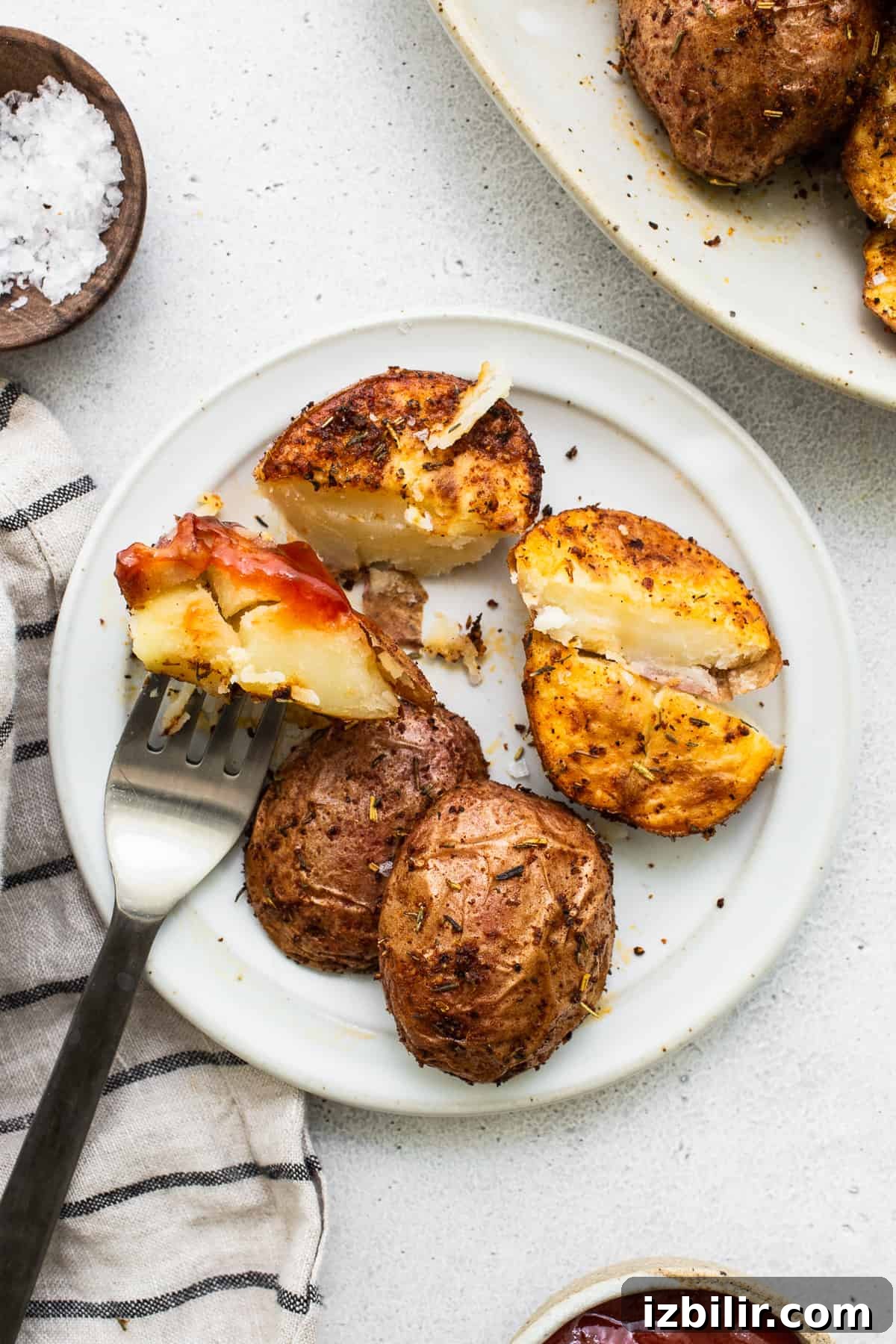 Air fryer potatoes with ketchup on a plate.