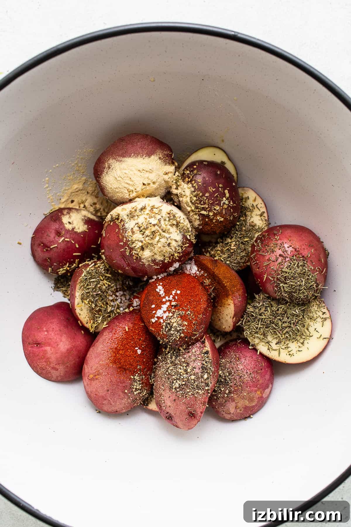 Air fryer potatoes in a bowl with spices.
