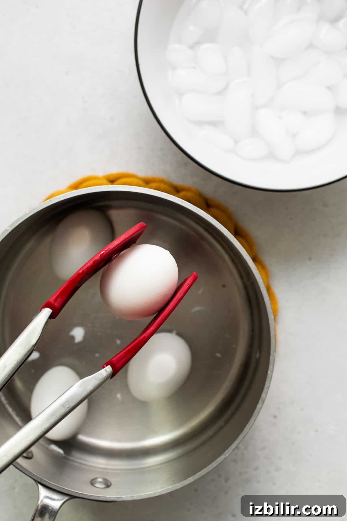 Soft boiled egg being held with tongs.