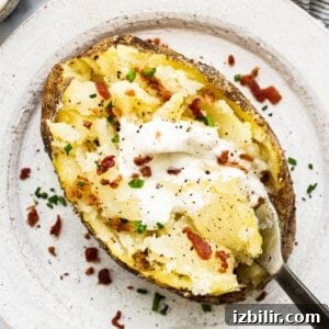 How to Make a Microwave Baked Potato 5 A baked potato topped with sour cream and bacon.