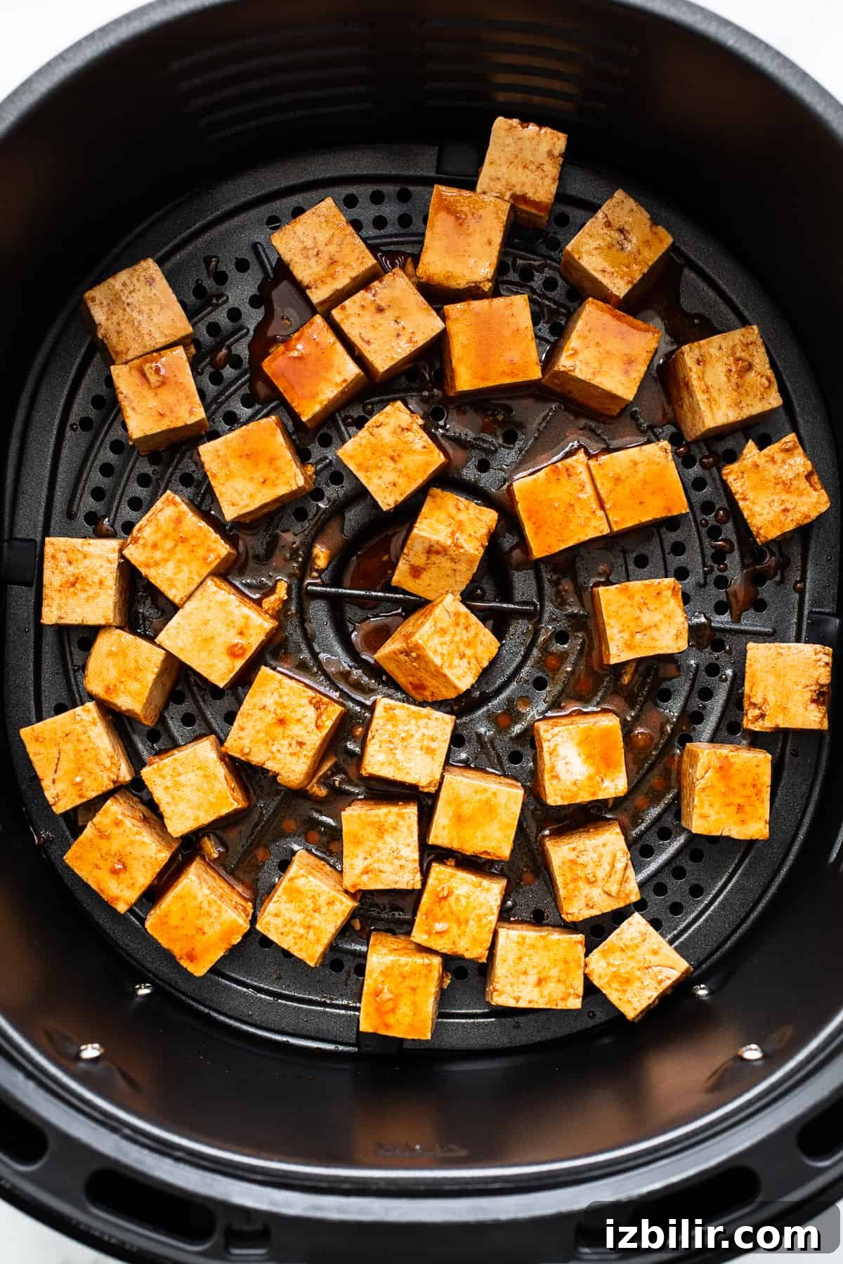 Placing the tofu in the air fryer.