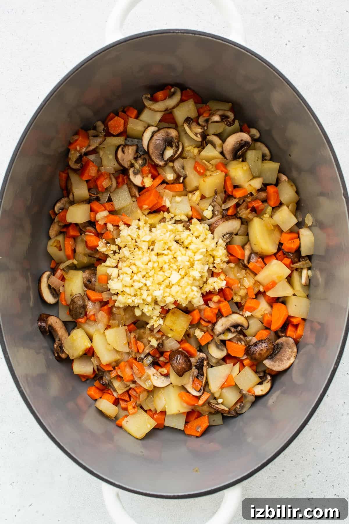 Comforting Homemade Chicken Soup Recipe 3 Minced garlic and vegetables in a le creuset.