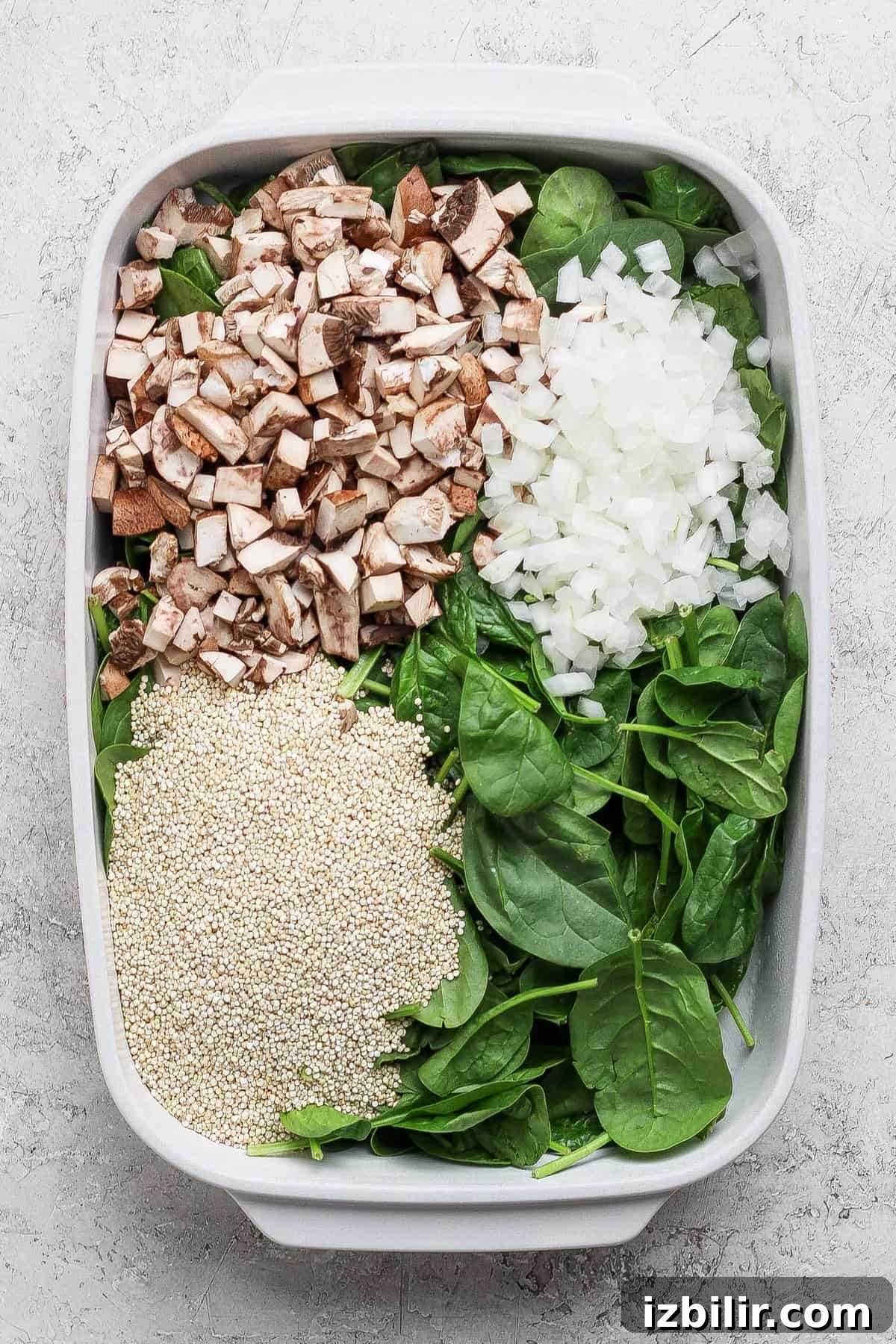 Spinach and Quinoa Lasagna Casserole Recipe 3 Chopped mushrooms, diced onion, fresh spinach, and uncooked quinoa in a baking dish