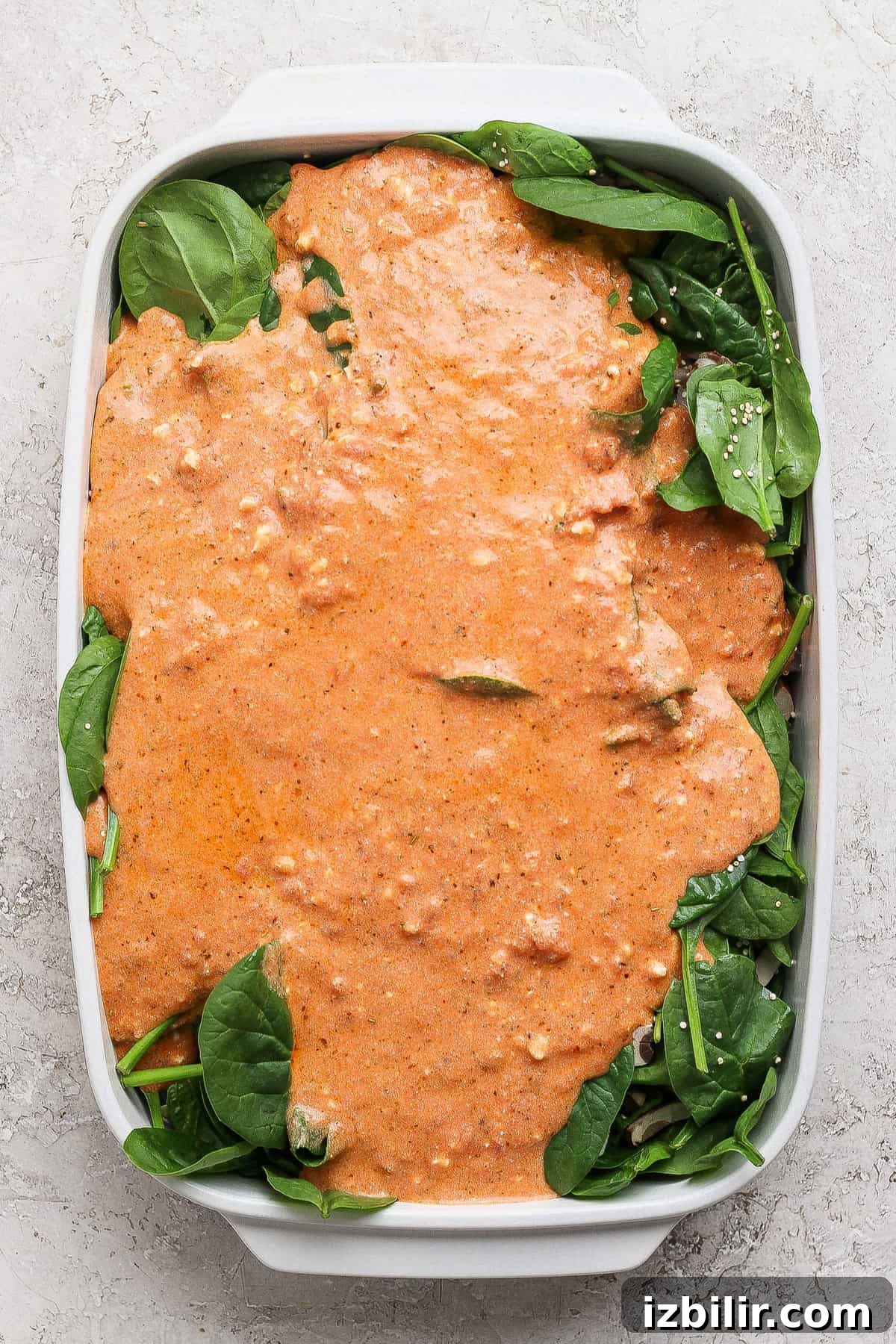 Spinach and Quinoa Lasagna Casserole Recipe 4 Layering cottage cheese sauce over fresh spinach in a baking dish