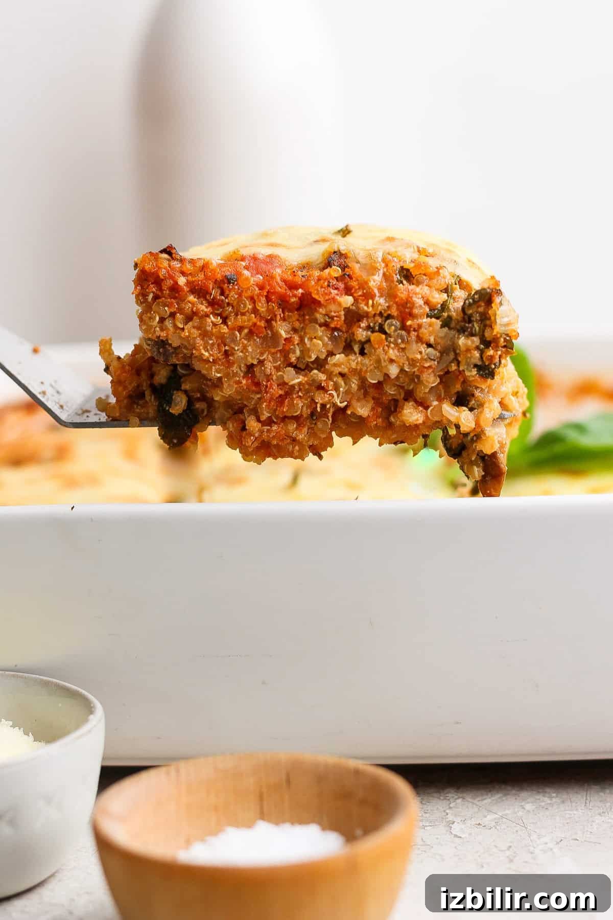 Spinach and Quinoa Lasagna Casserole Recipe 6 Lifting a slice of spinach quinoa lasagna casserole from the baking dish with a spatula