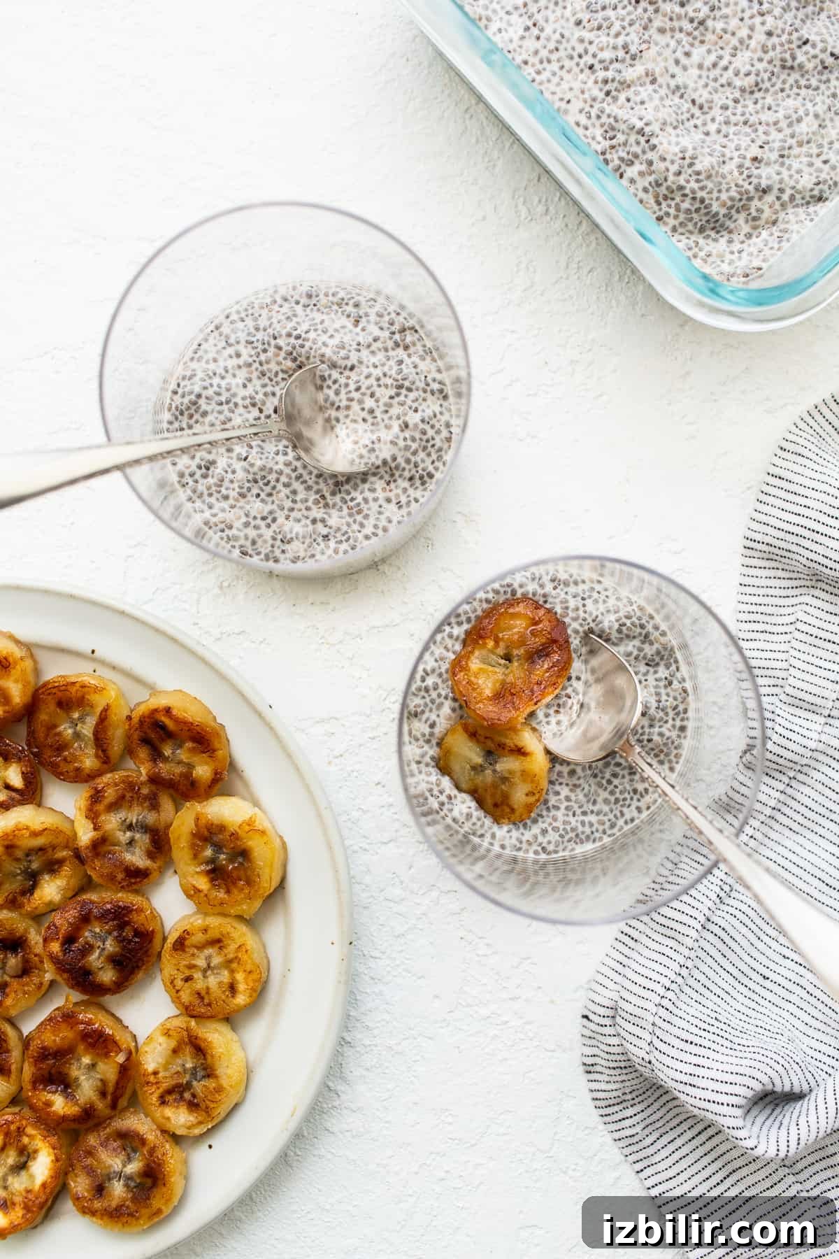 Layered chia pudding with caramelized bananas and graham cracker crumbs. Chia seed pudding in glasses topped with caramelized bananas.