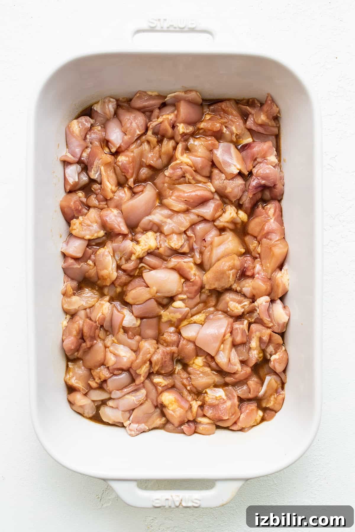 chicken marinating in casserole dish.