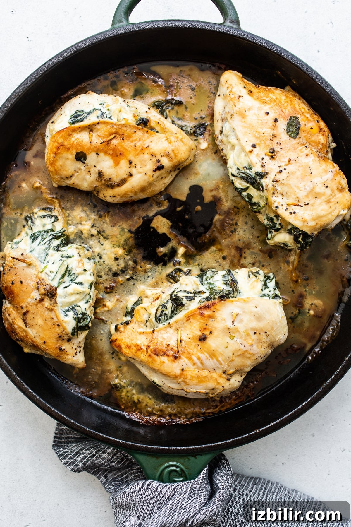 Searing stuffed chicken Stuffed chicken breast cooking in a skillet.