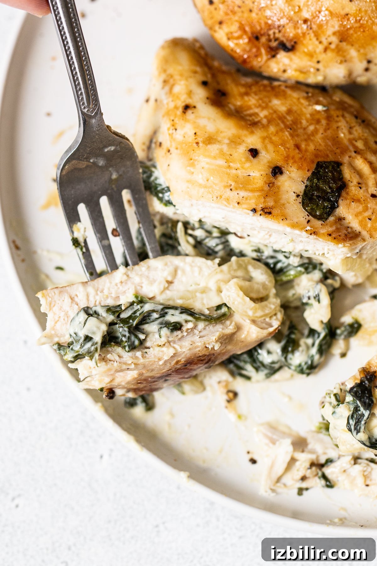Sliced spinach stuffed chicken Slice of a spinach stuffed chicken breast on a plate.