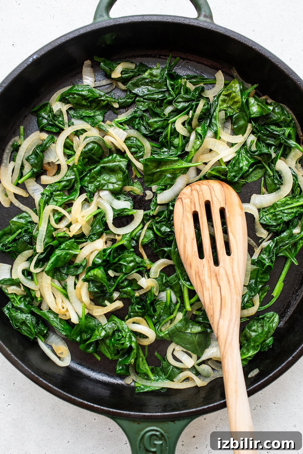 Spinach and onions sautéing Spinach and onions sauteing in a skillet.
