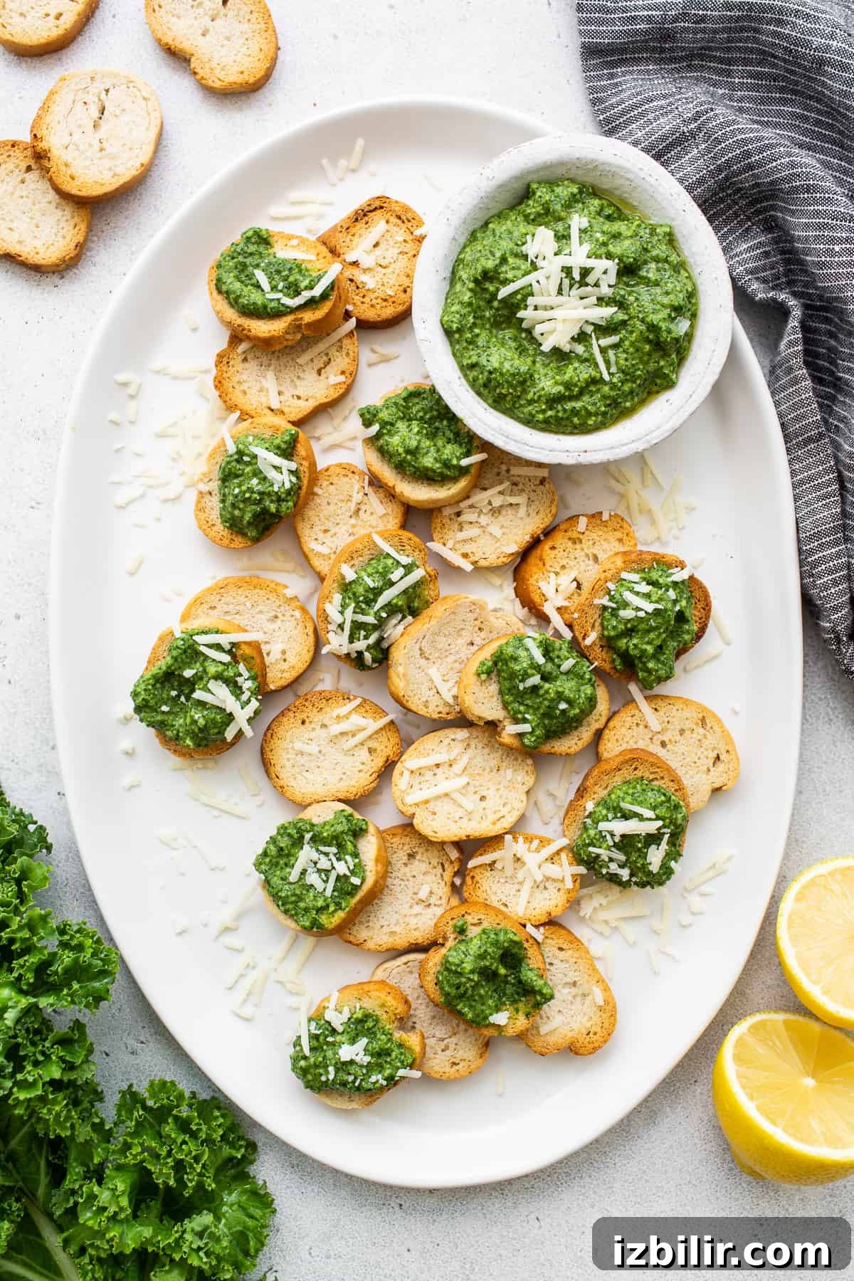 Make this easy kale pesto recipe with fresh kale, walnuts, olive oil, lemon juice, and parmesan cheese. It's the perfect complement to pasta dishes, as a dip or a marinade. Kale pesto on crostini.