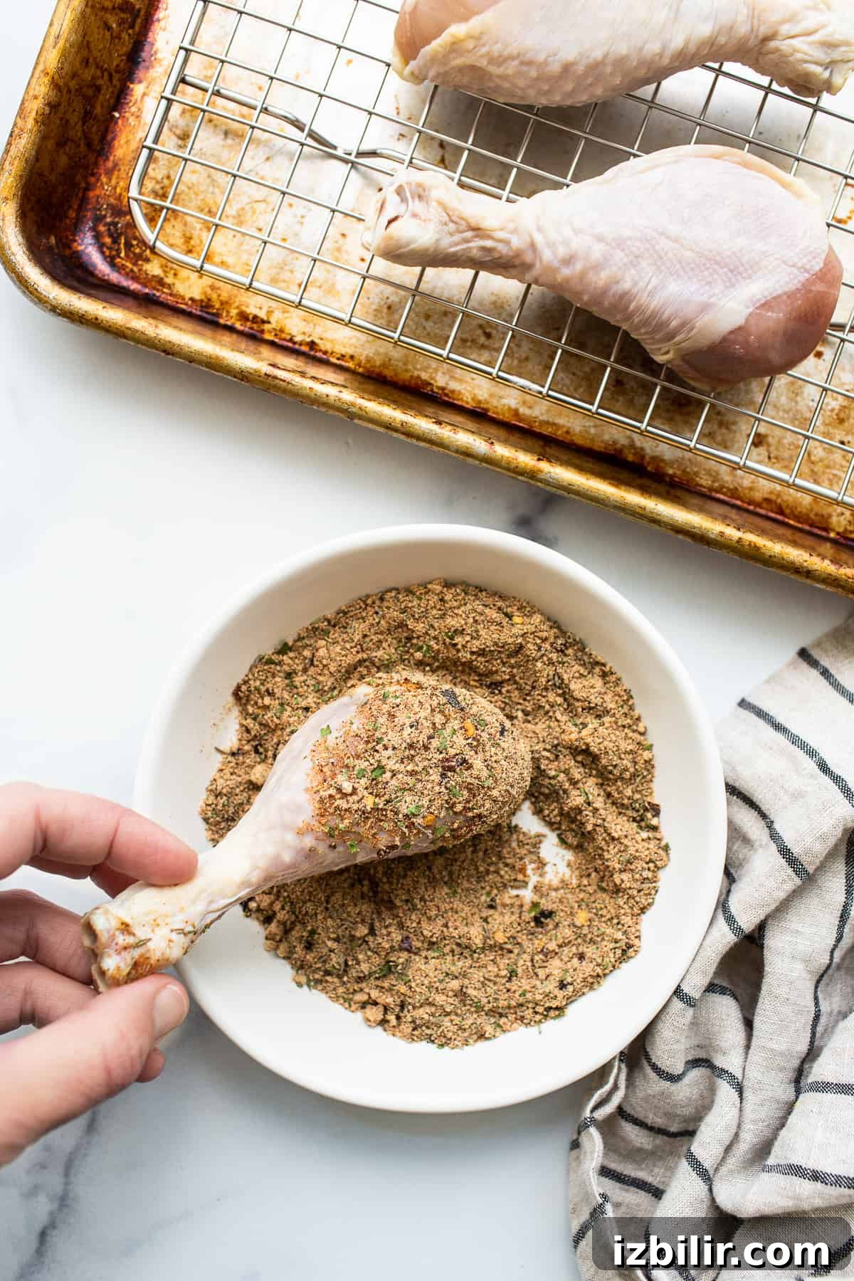 Chicken legs being seasoned. Chicken legs being rolled in chicken seasoning.