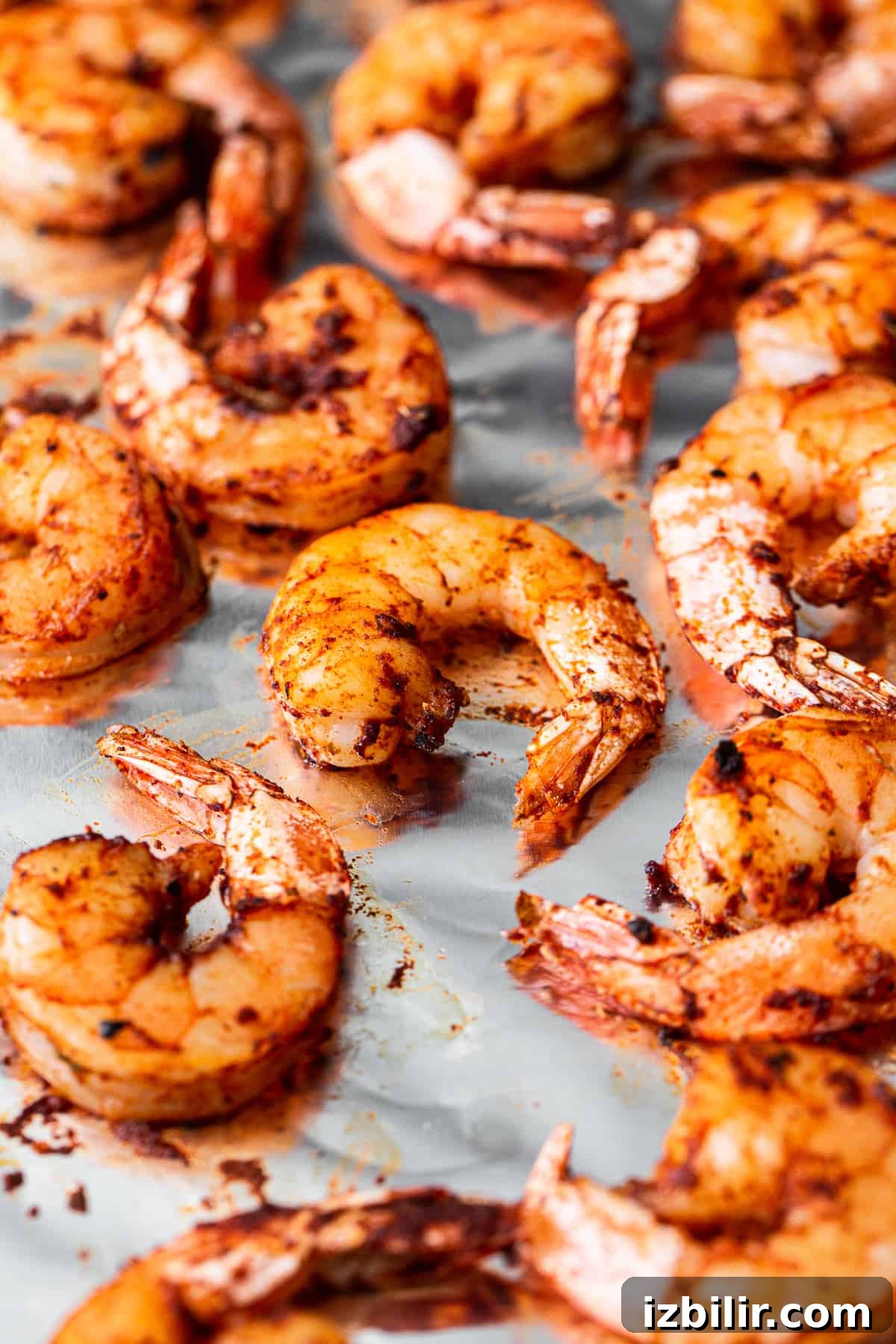 Broiled shrimp on a baking sheet.