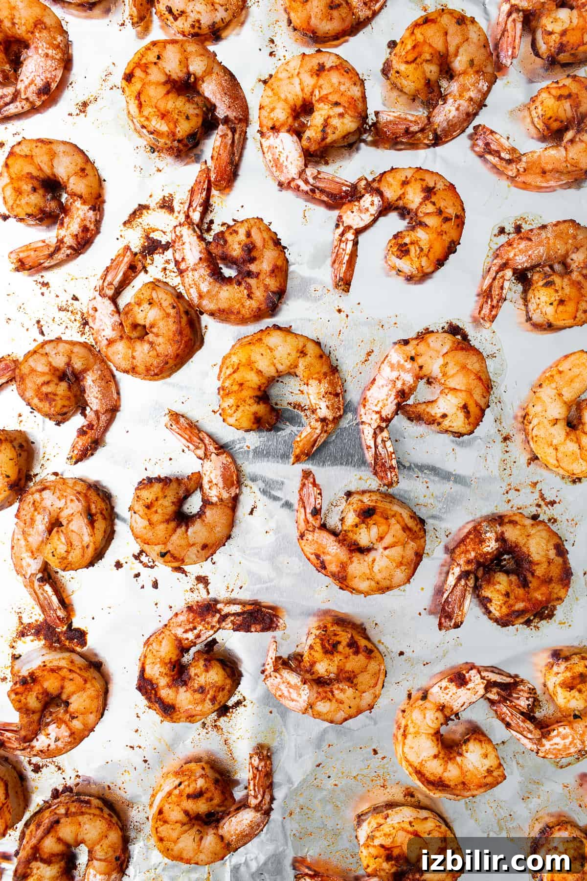 Broiled shrimp on a baking sheet.