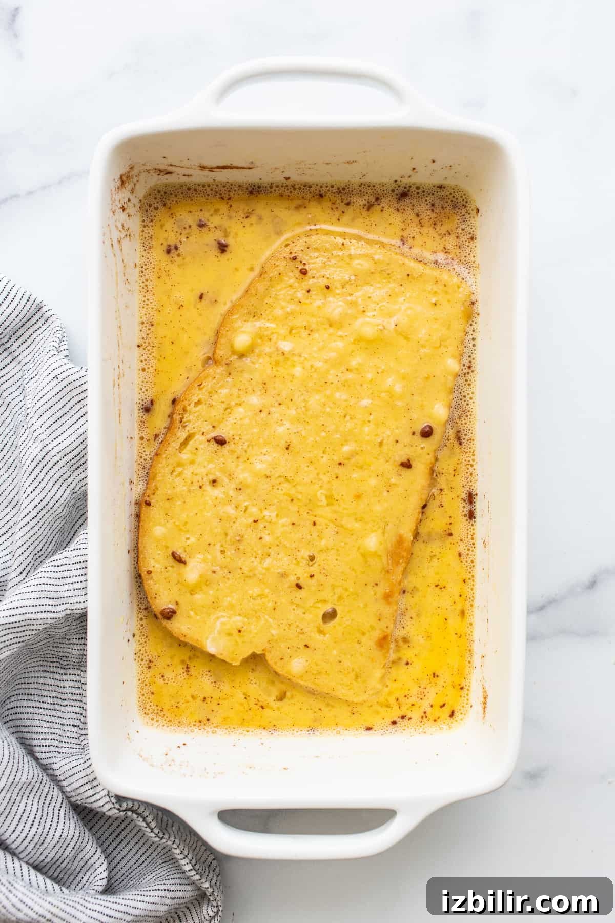 Air fryer french toast in an egg wash.