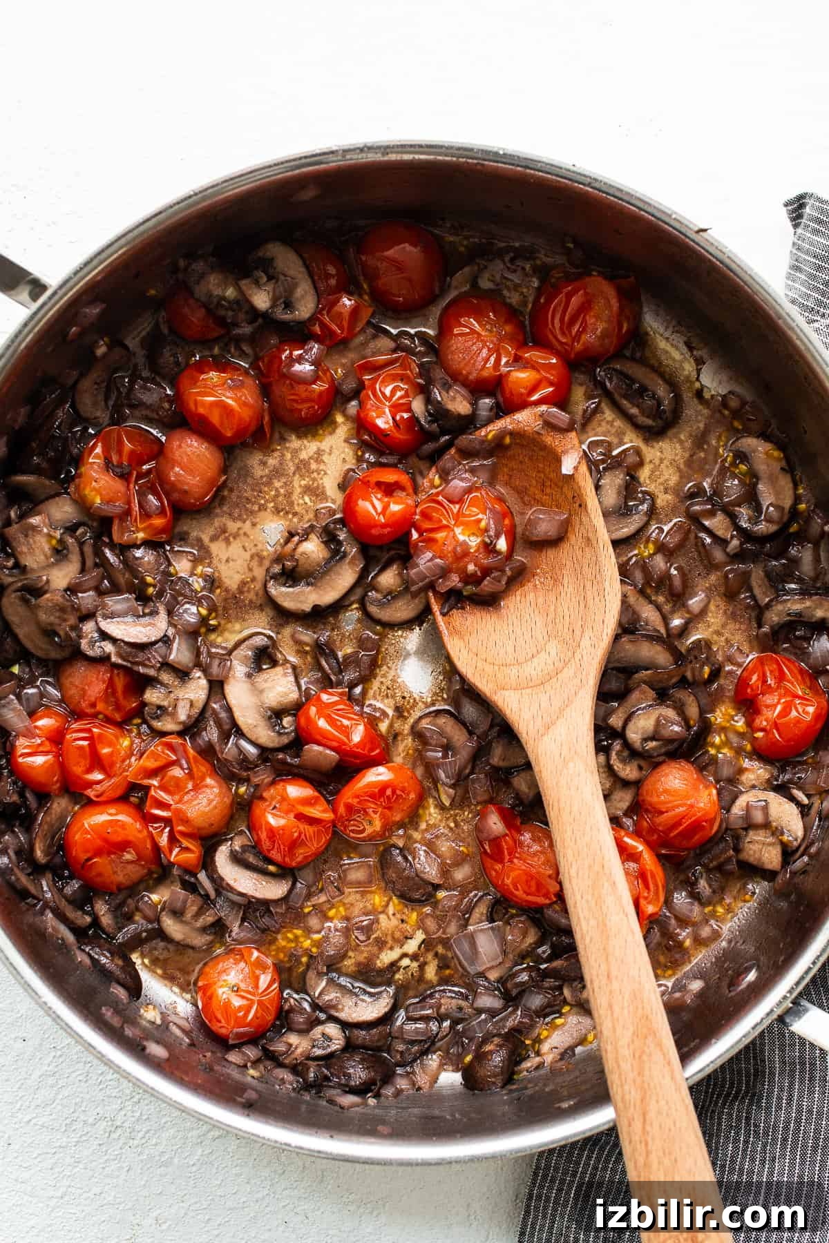 Sautéing mushrooms and tomatoes Mushrooms and tomatoes sautéing in a skillet.