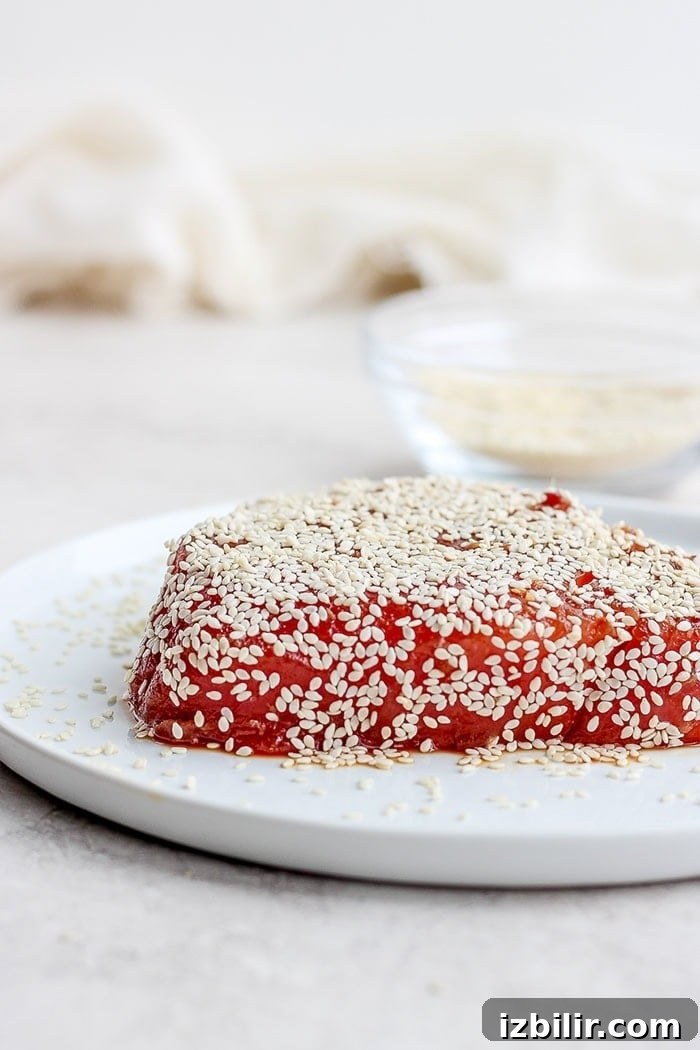 Ahi tuna covered in sesame seeds. Ahi tuna covered in sesame seeds on a plate.