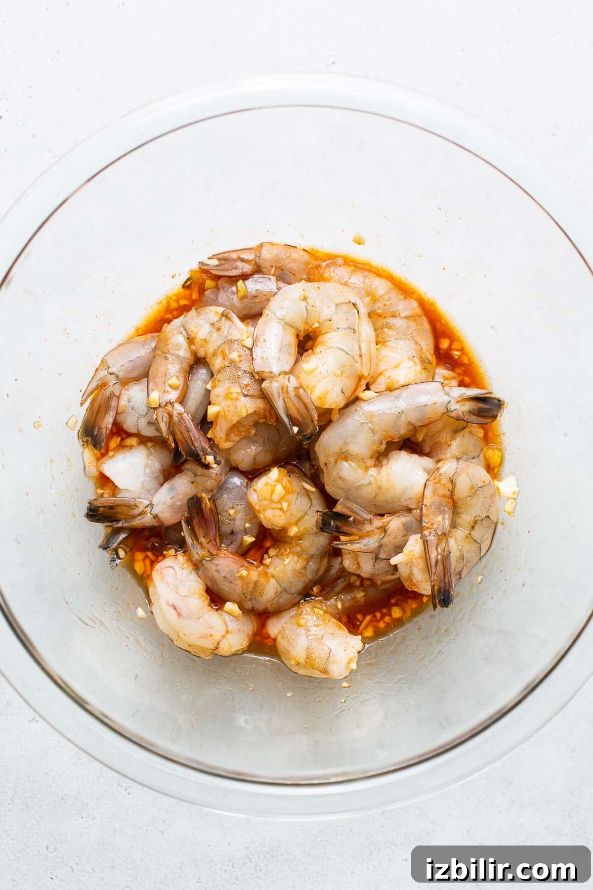 Raw prawns marinating in a bowl.